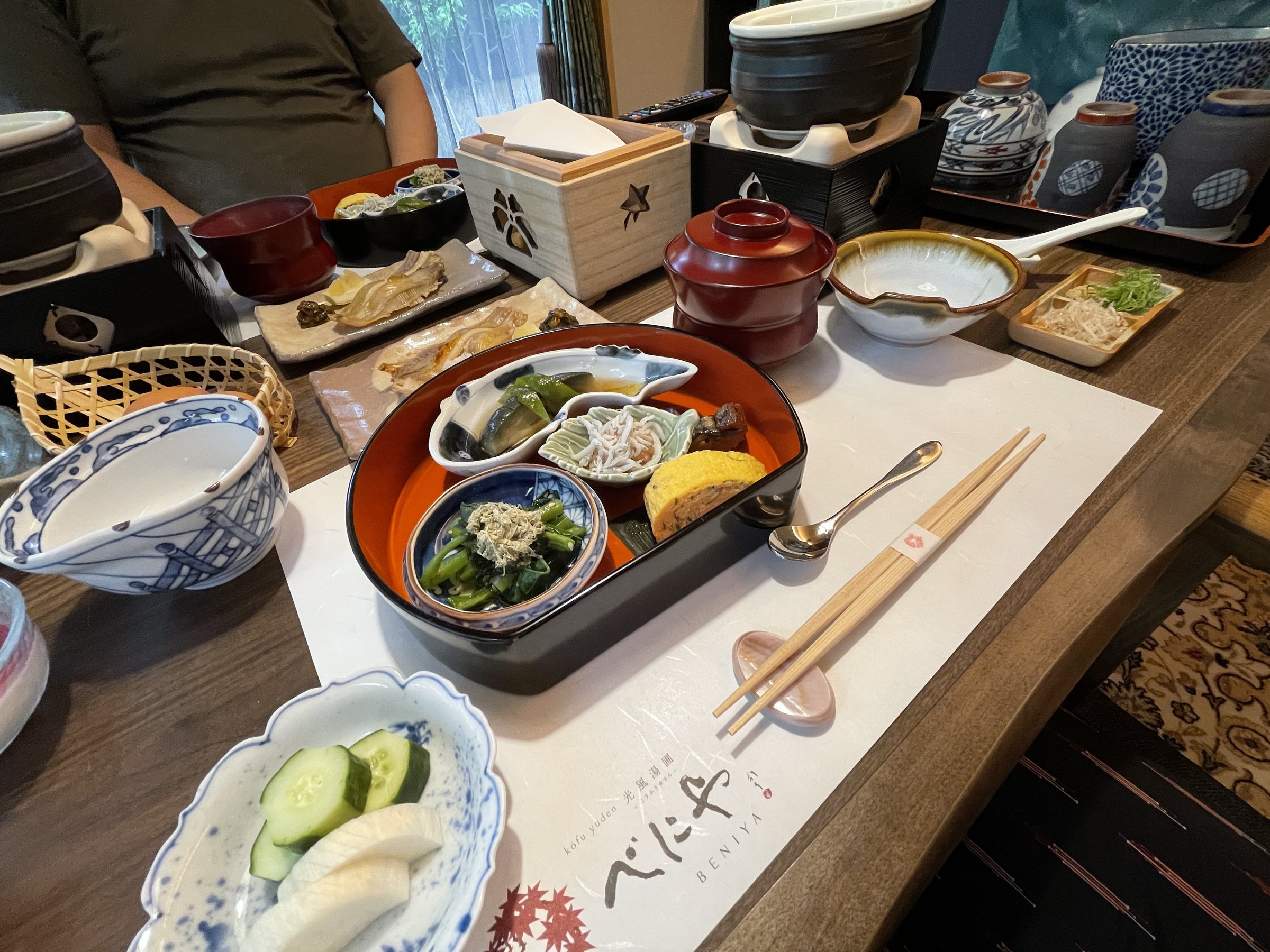 The Japanese breakfast laid out on the table, with small dishes and pickles.