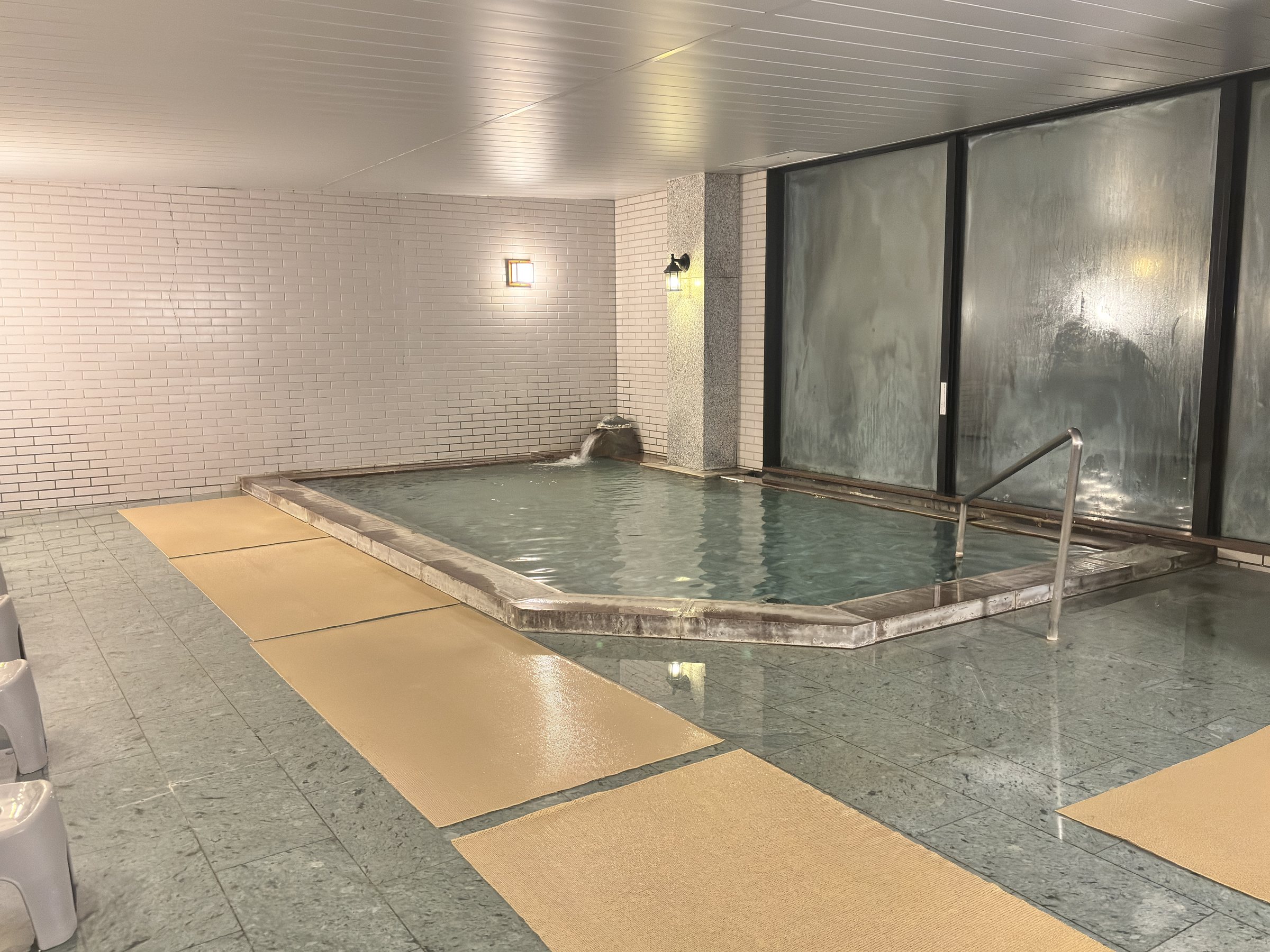 The indoor bath: a long pool beneath tall windows.
