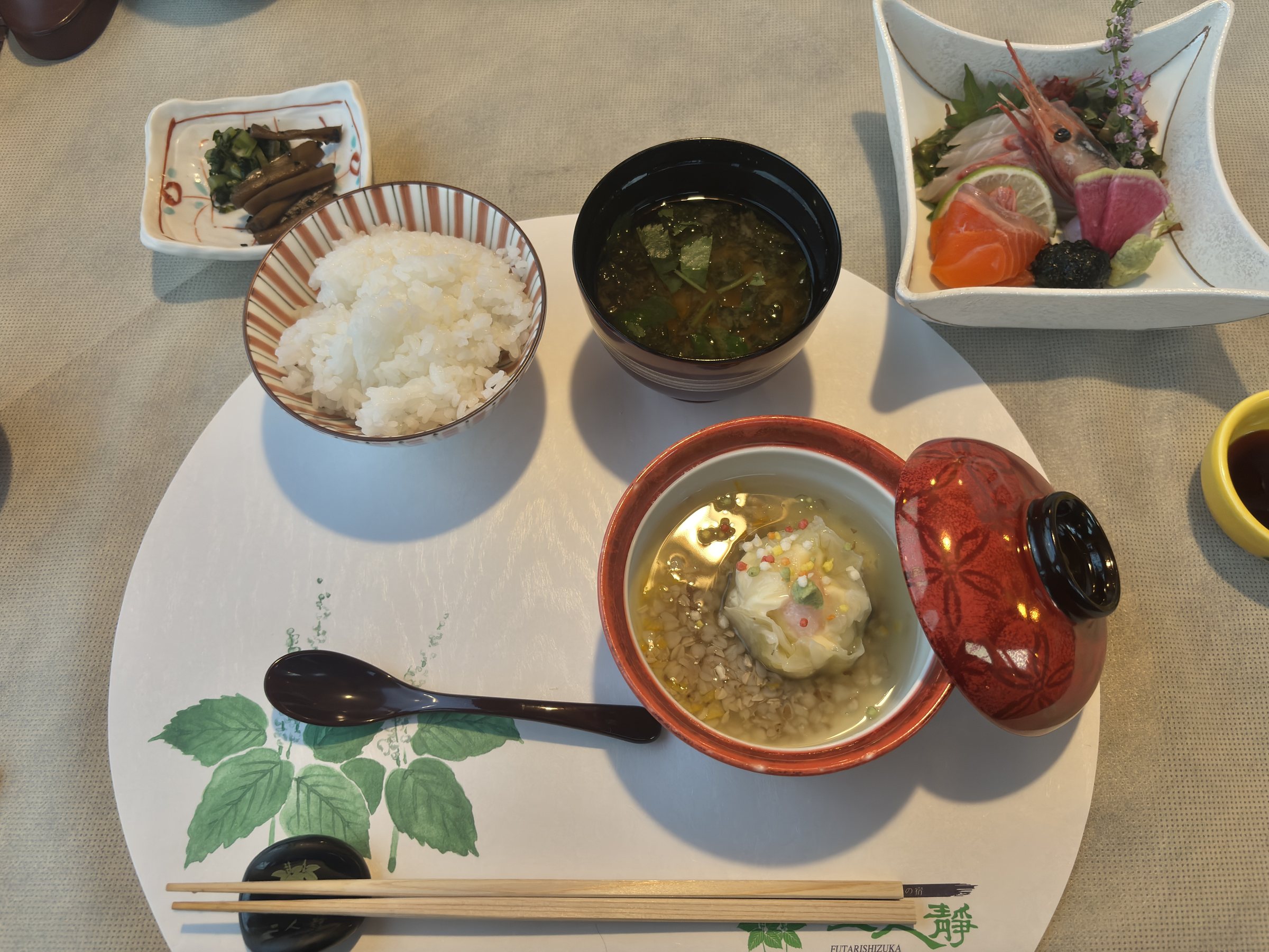 Rice, red miso soup, a lidded red bowl and the remaining sashimi.