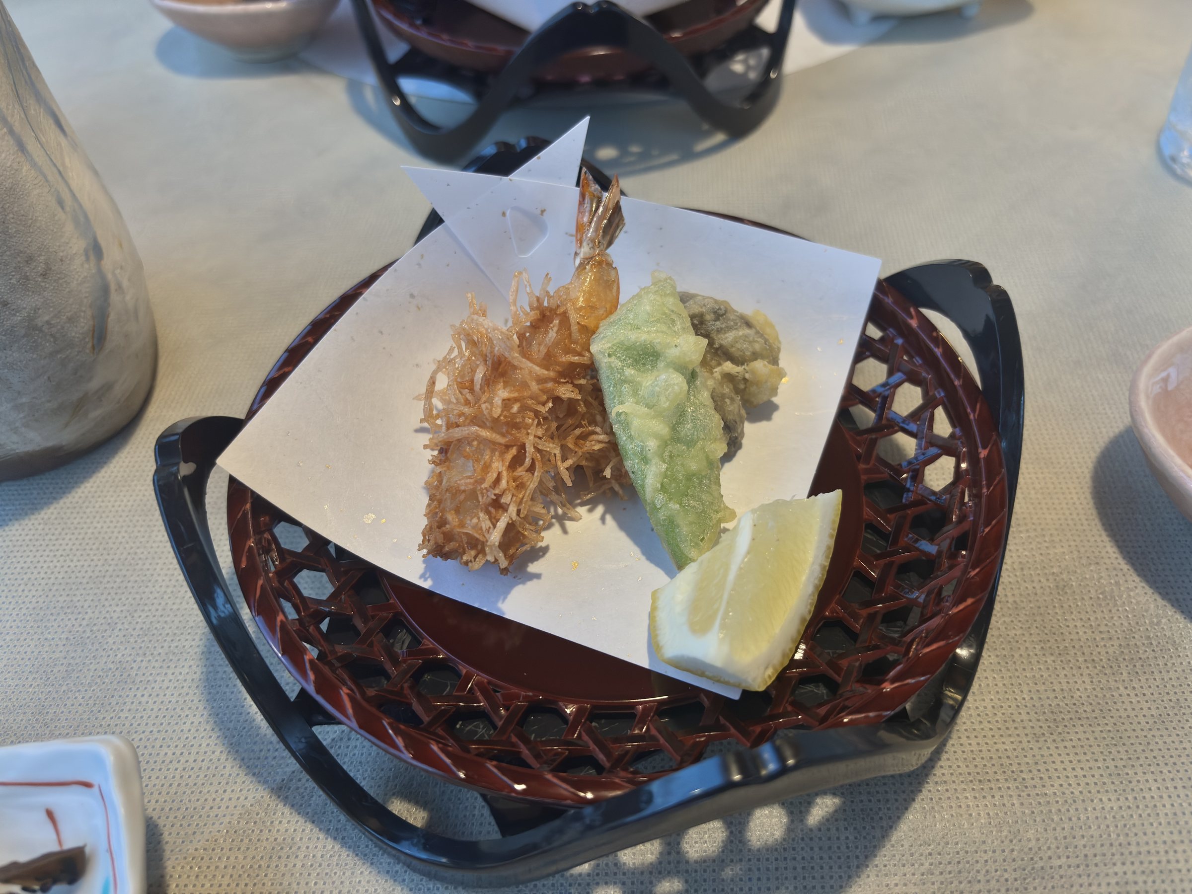 Crisp-fried shrimp and vegetable tempura in a lacquered basket.