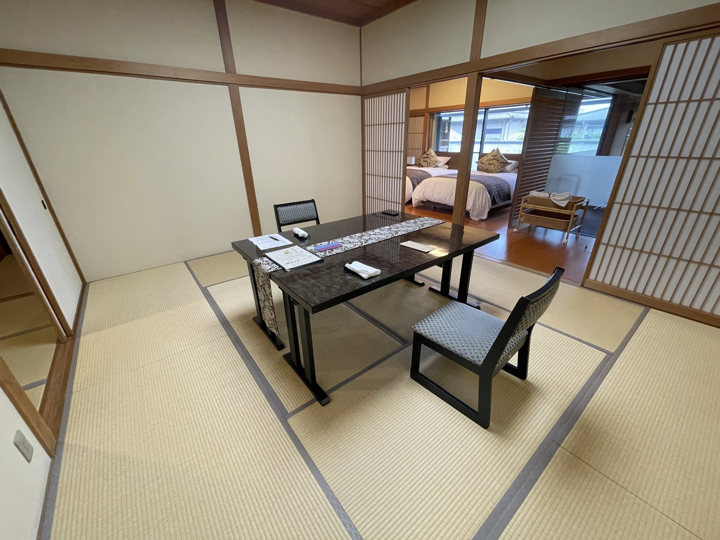 The sitting room opens through sliding screens to the bedroom beyond.