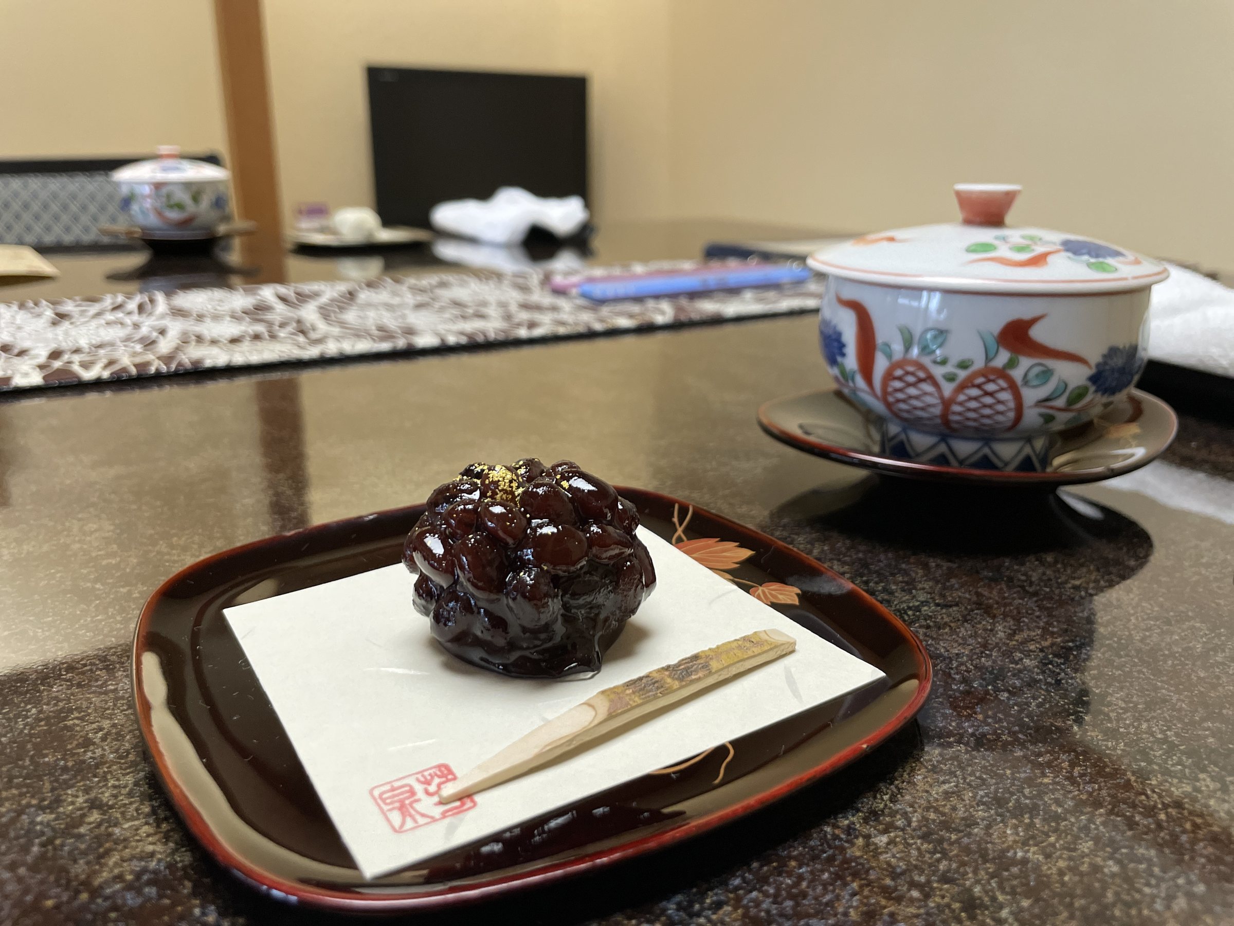 A handmade Japanese sweet and tea on a lacquered tray.