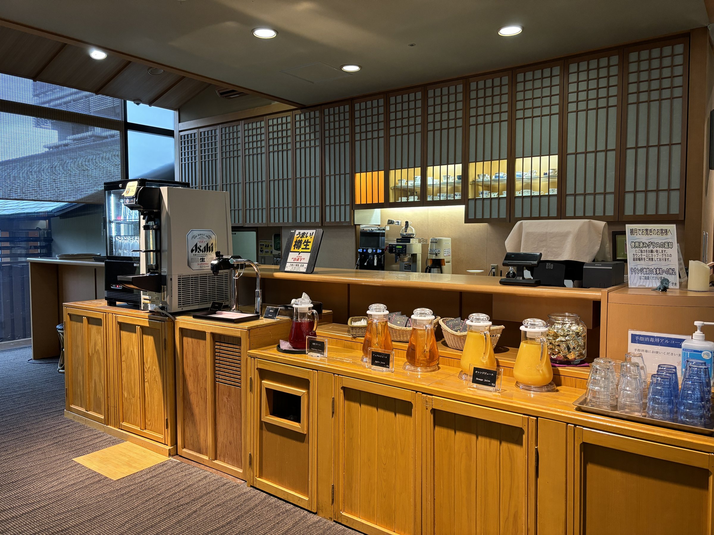 The self-service drinks corner where guests wait before check-in.