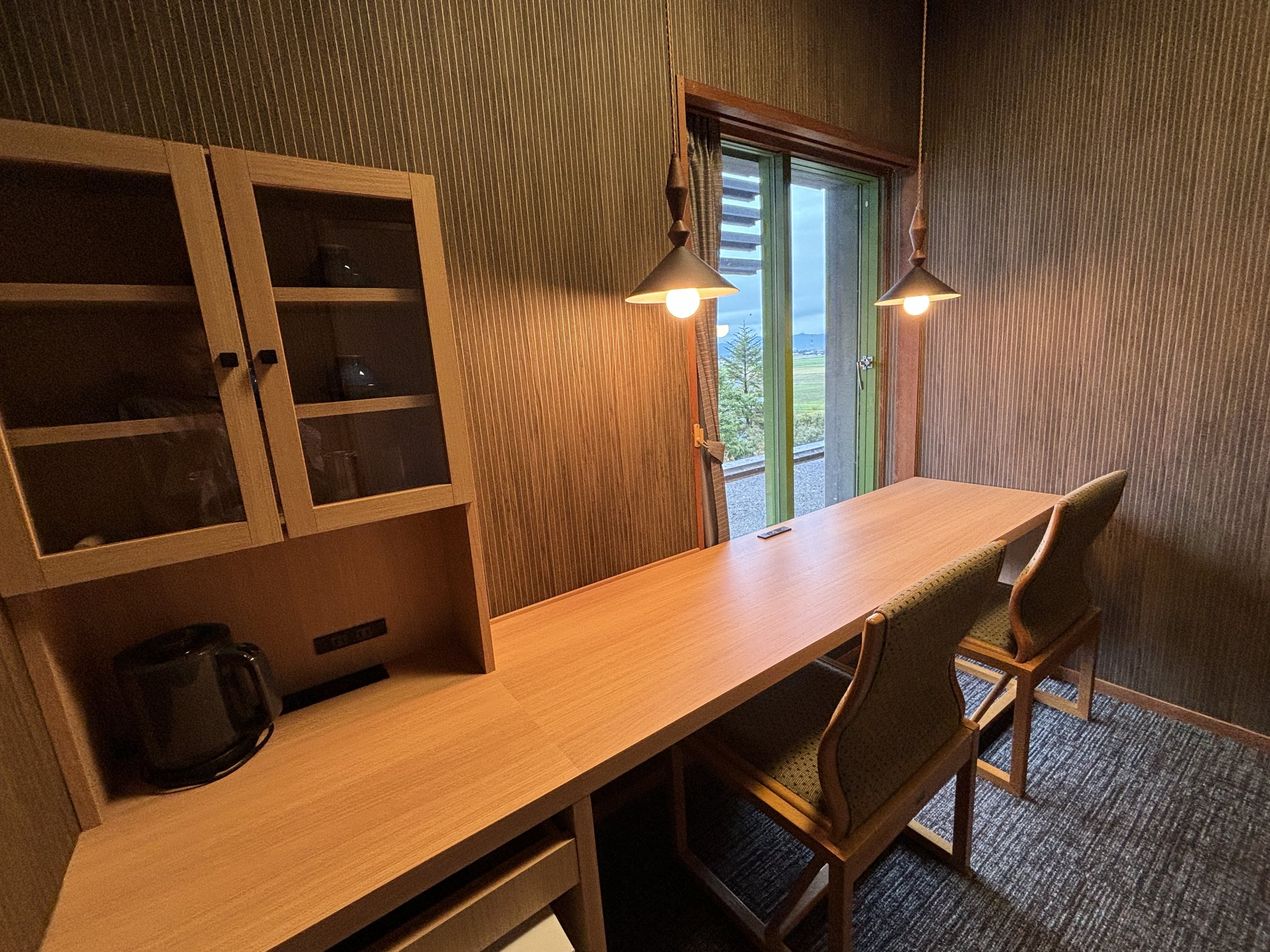 The separate remote-work room, with a long desk and pendant lamps.