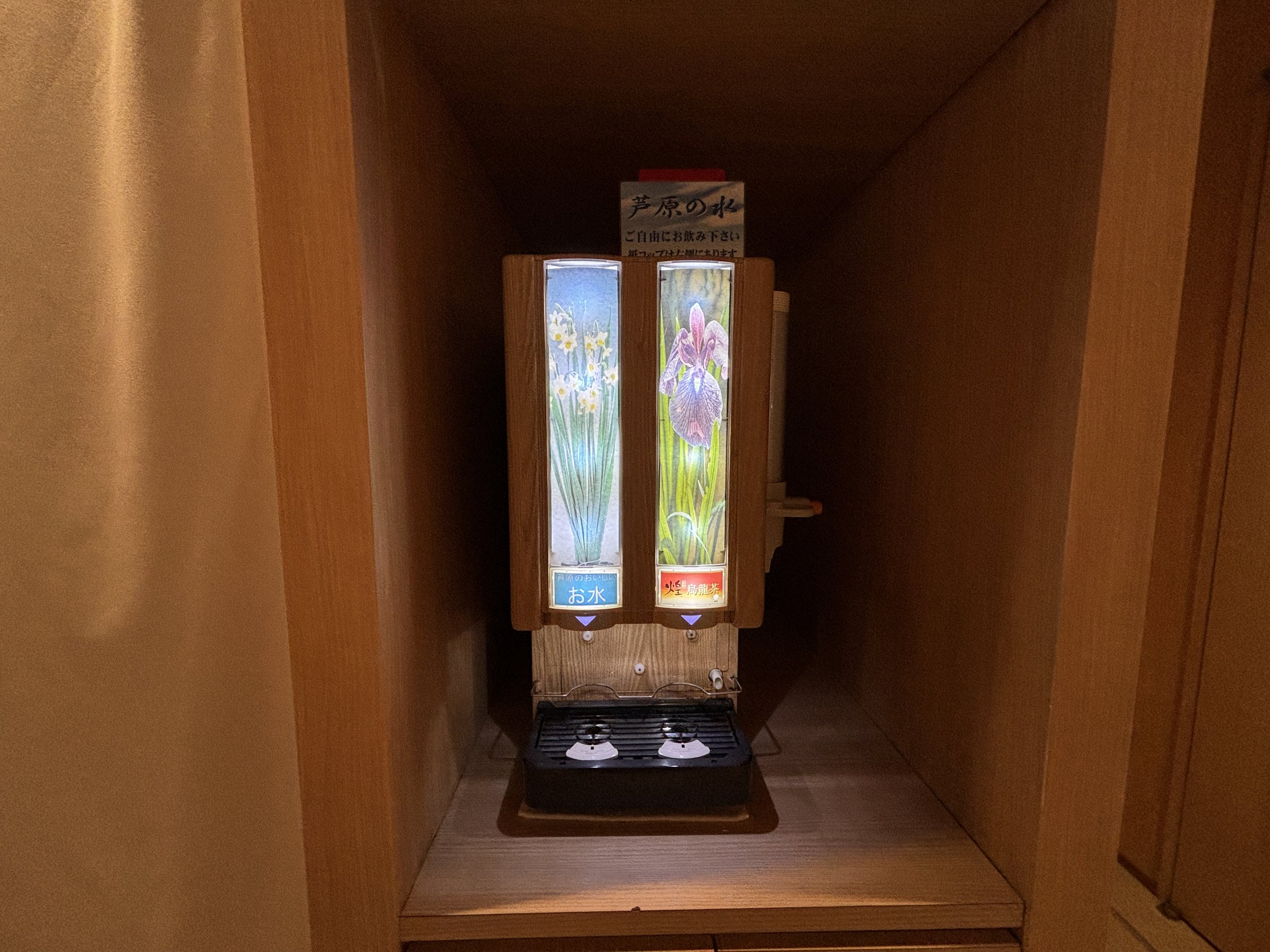 A soft-drink dispenser in a wooden alcove.