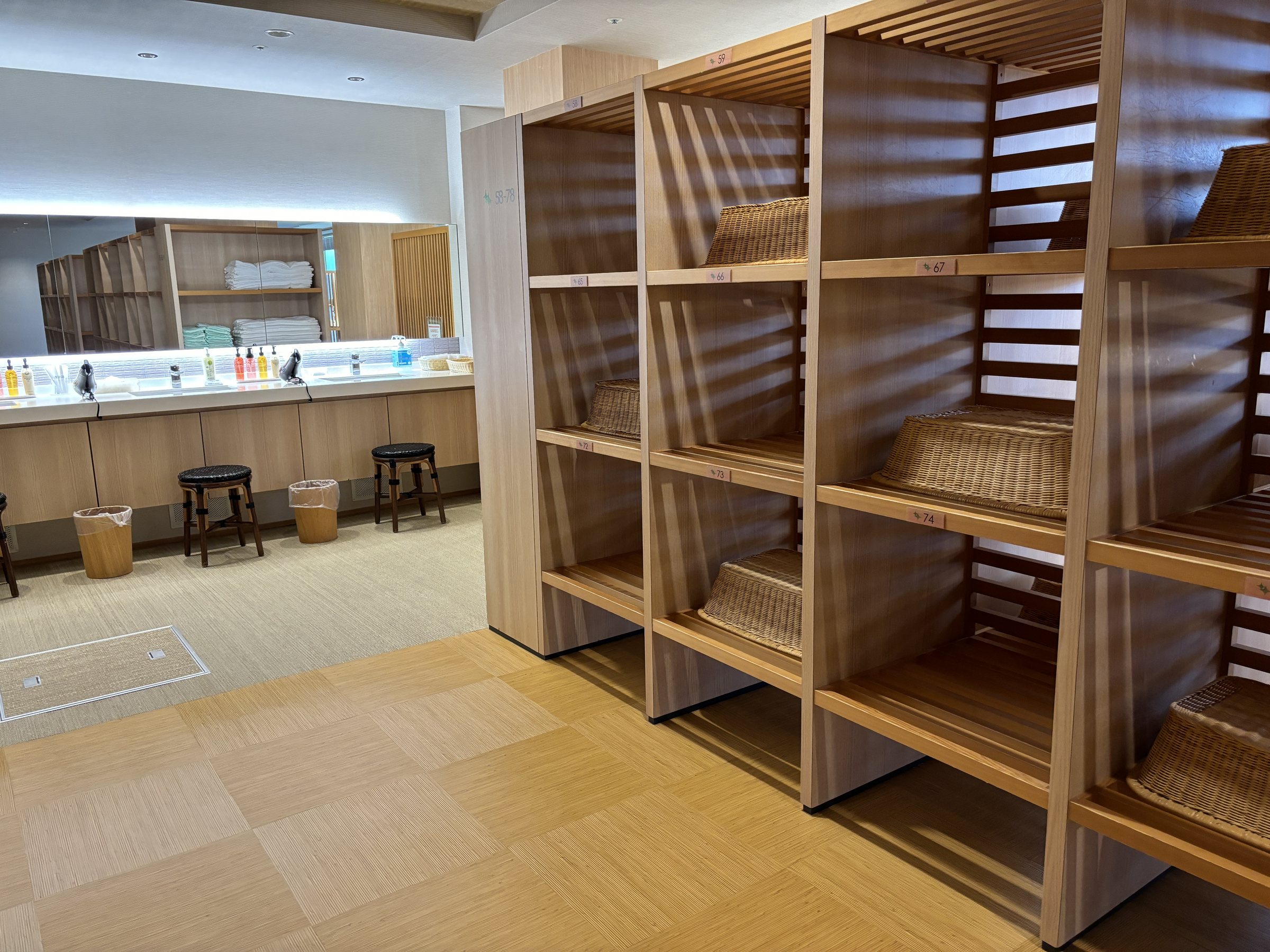 The changing room, with wooden shelves and baskets.