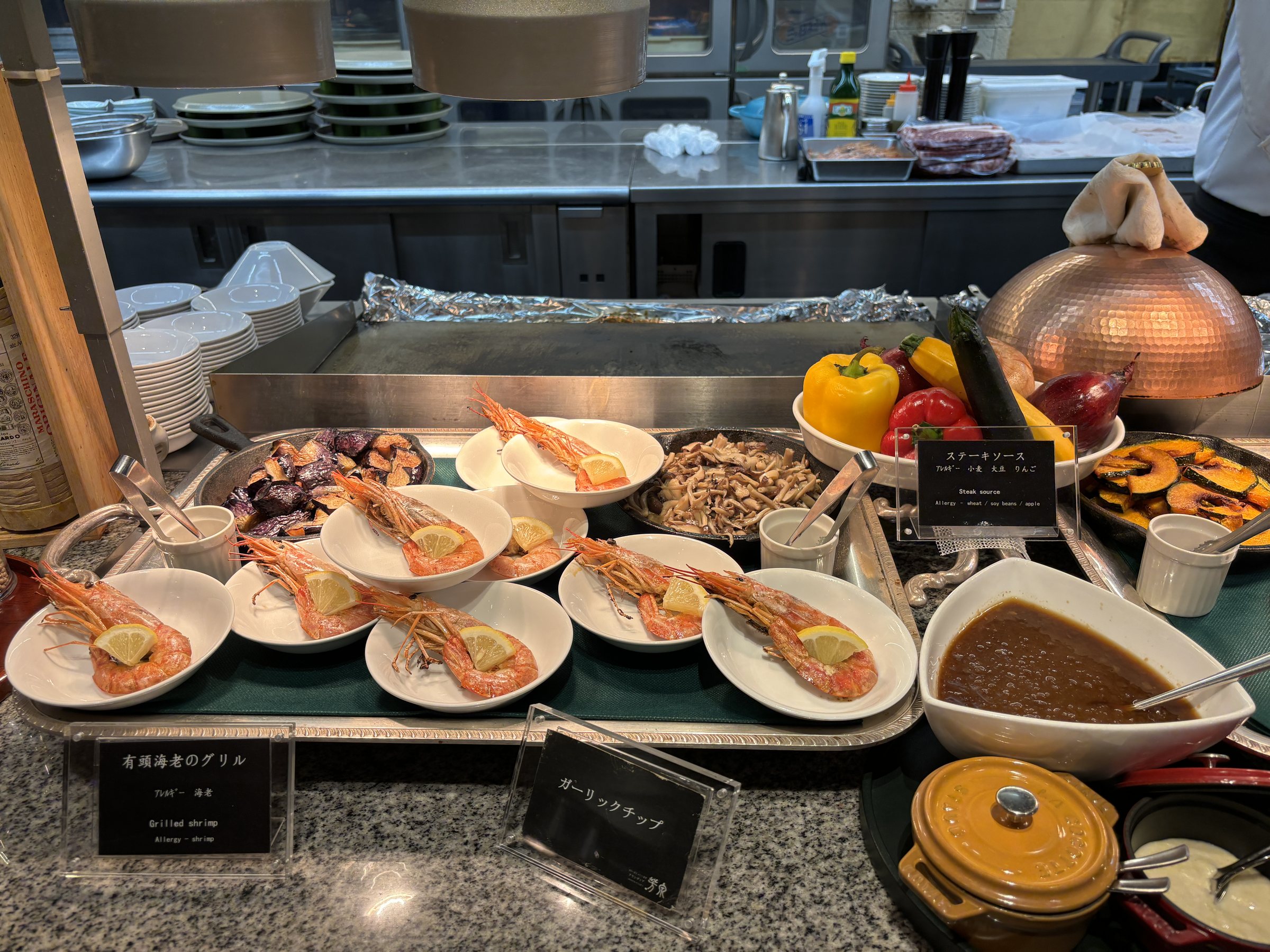 Crab and prawns on small plates at one of the stations.