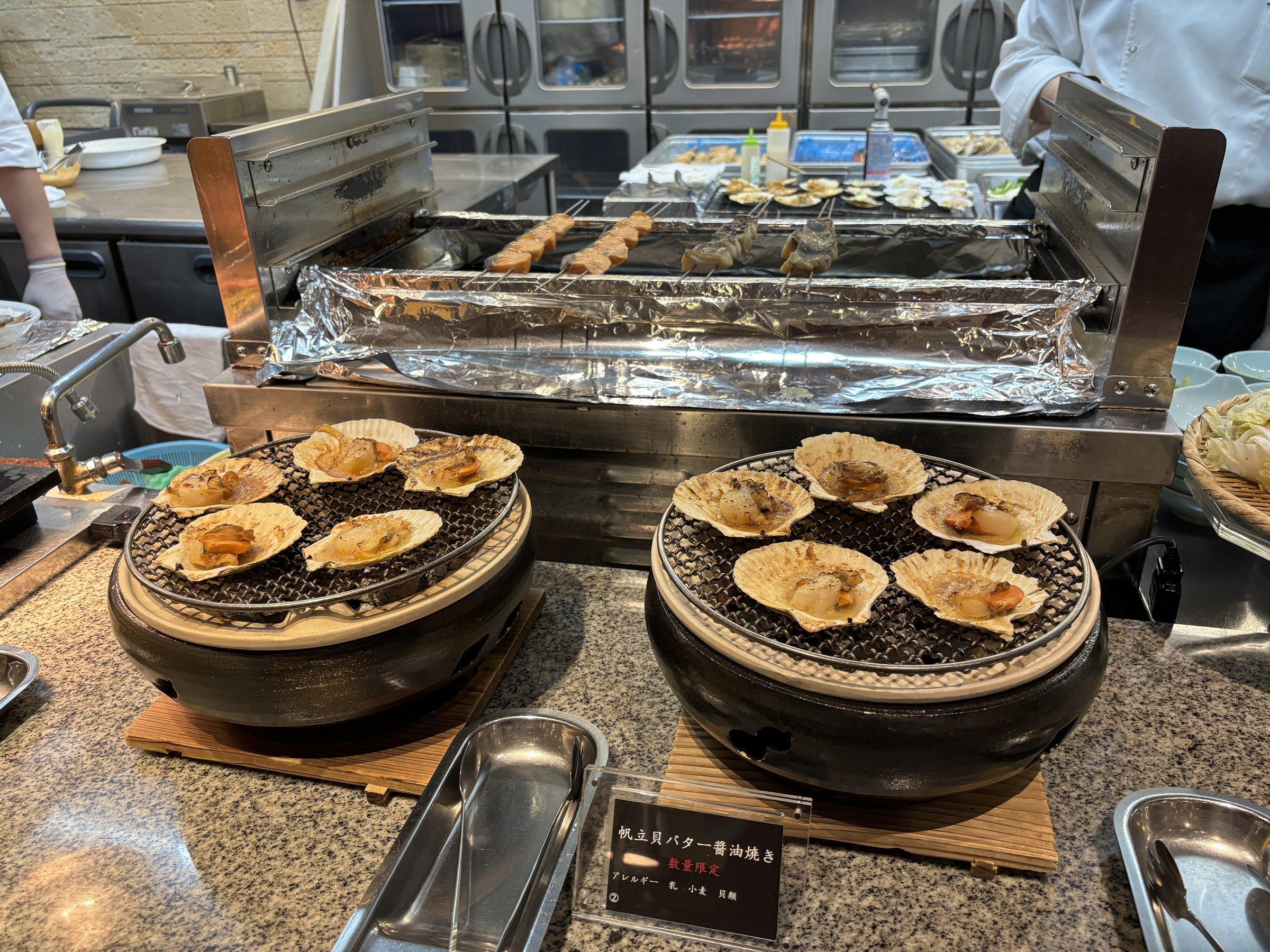 Scallops cooking on tabletop grills.