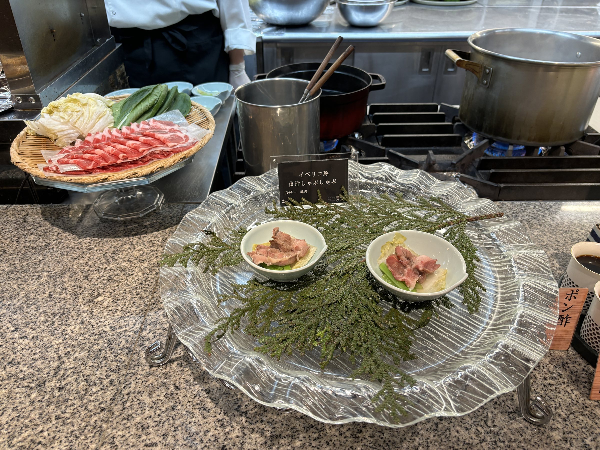 Small bowls on a glass platter, with sliced beef behind.