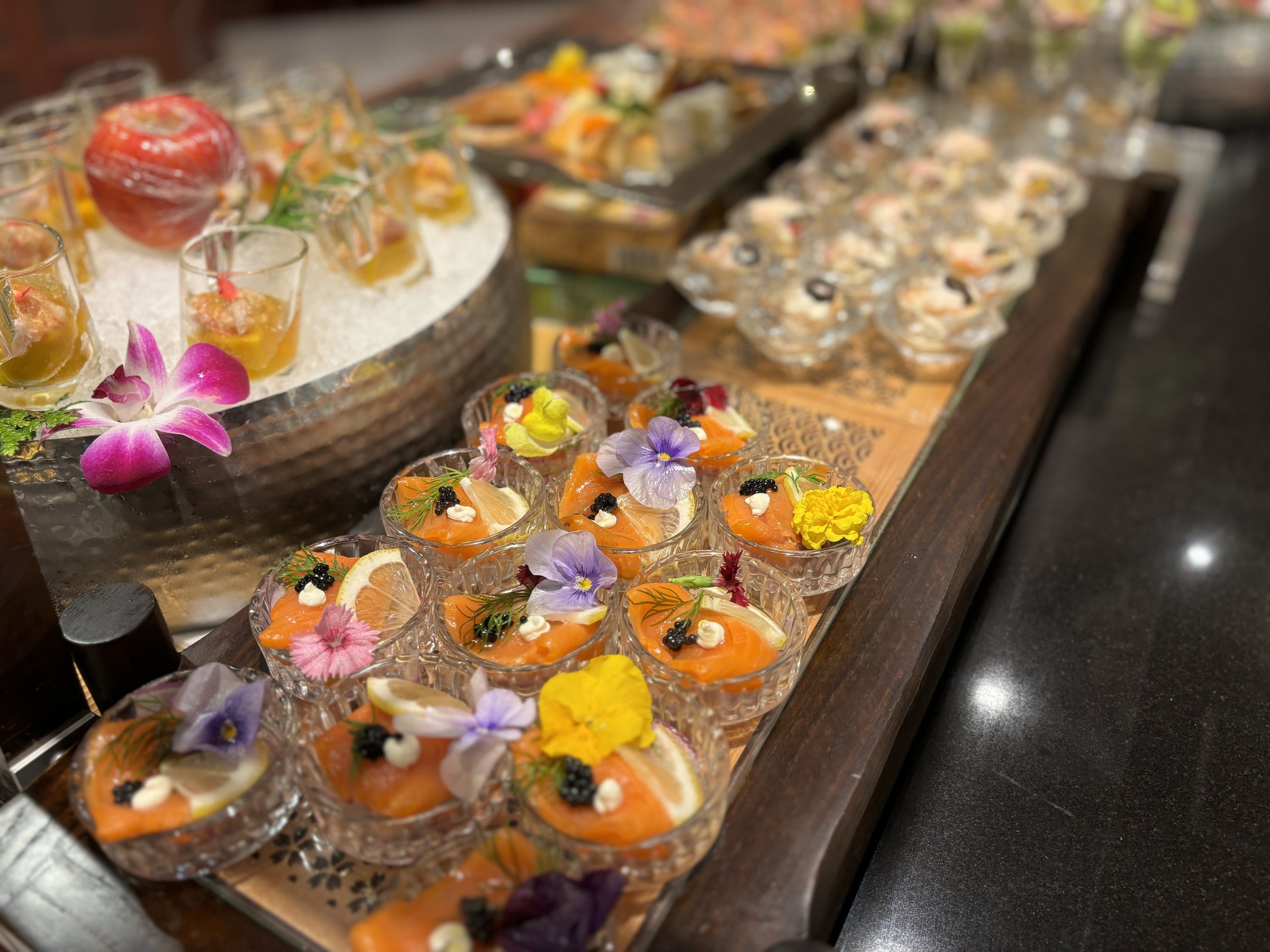 Rows of small glasses garnished with flowers.