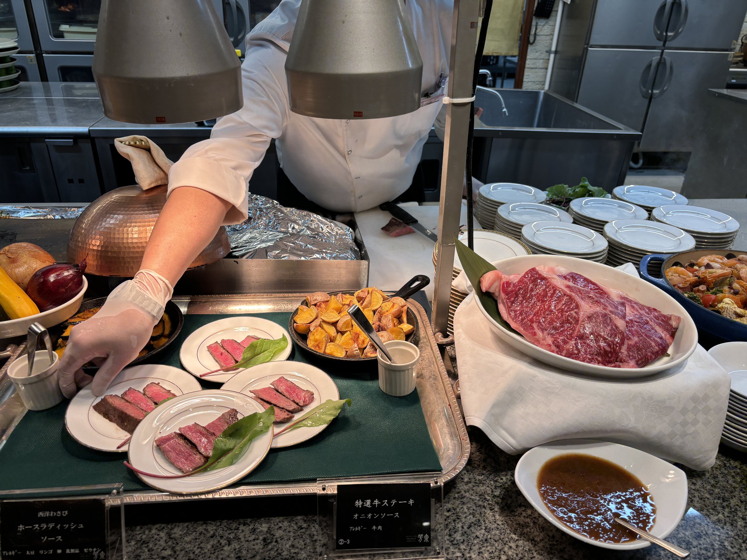 A chef plating steak at the live counter.