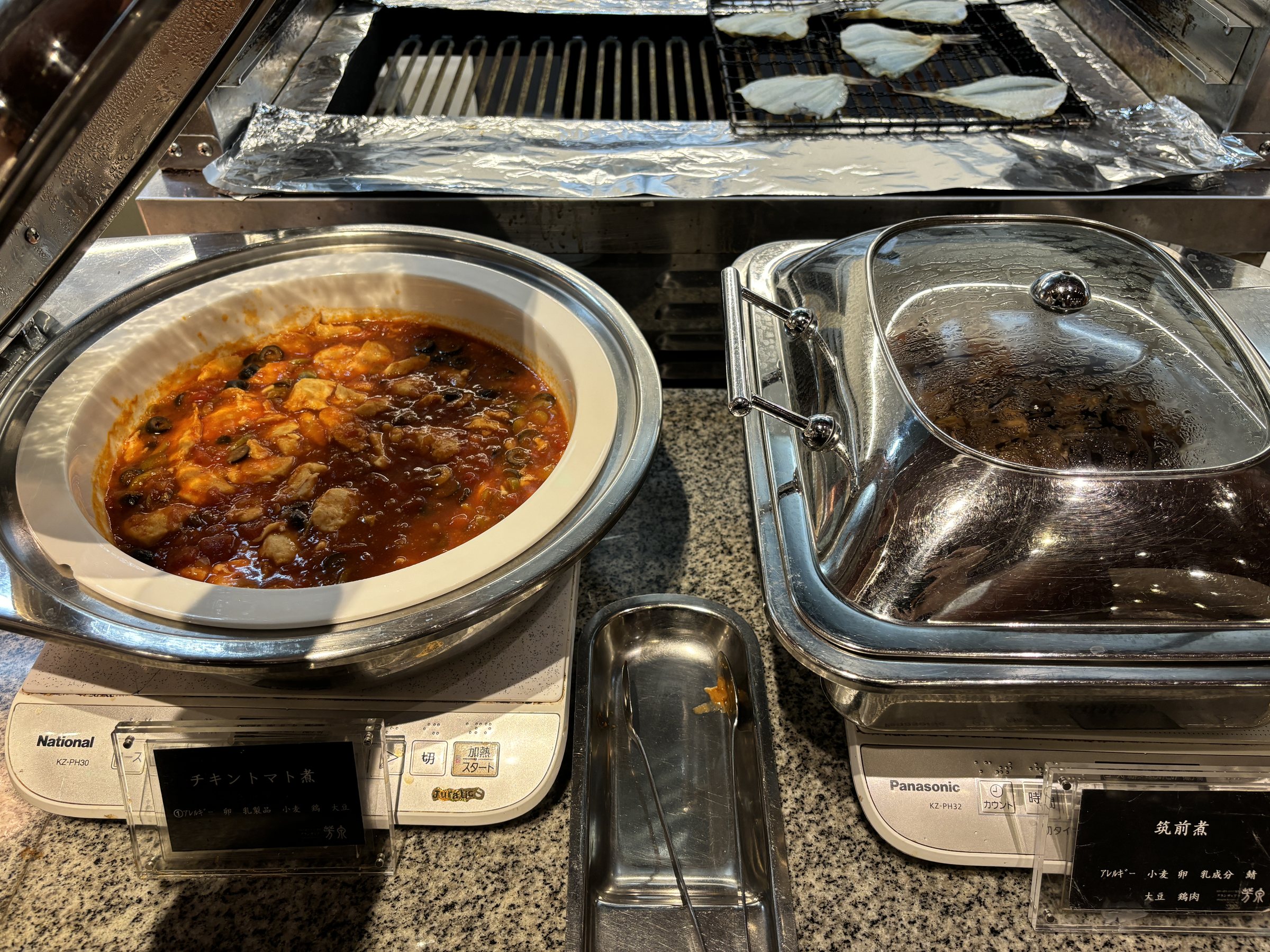 A red, spicy-looking stew kept warm in a chafing dish.