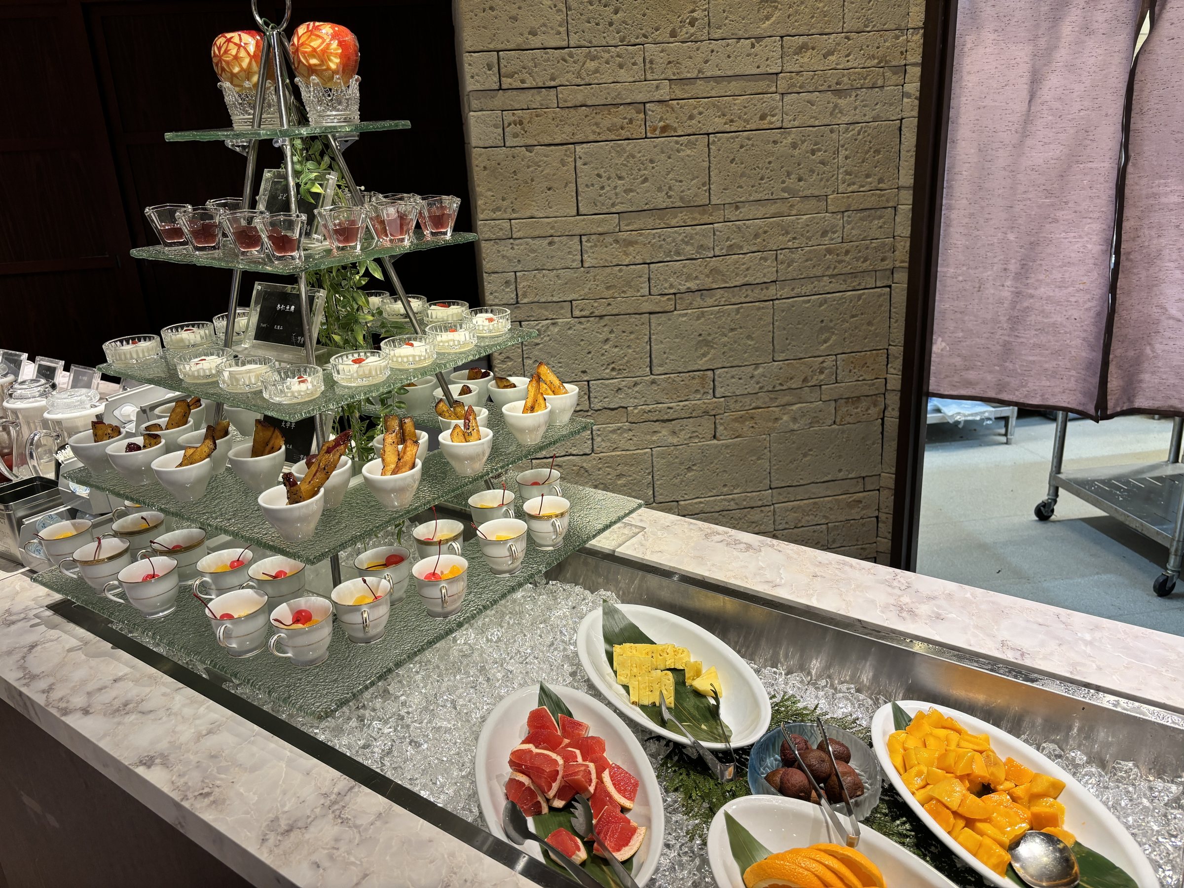 Fruit and small dessert cups on a tiered stand.