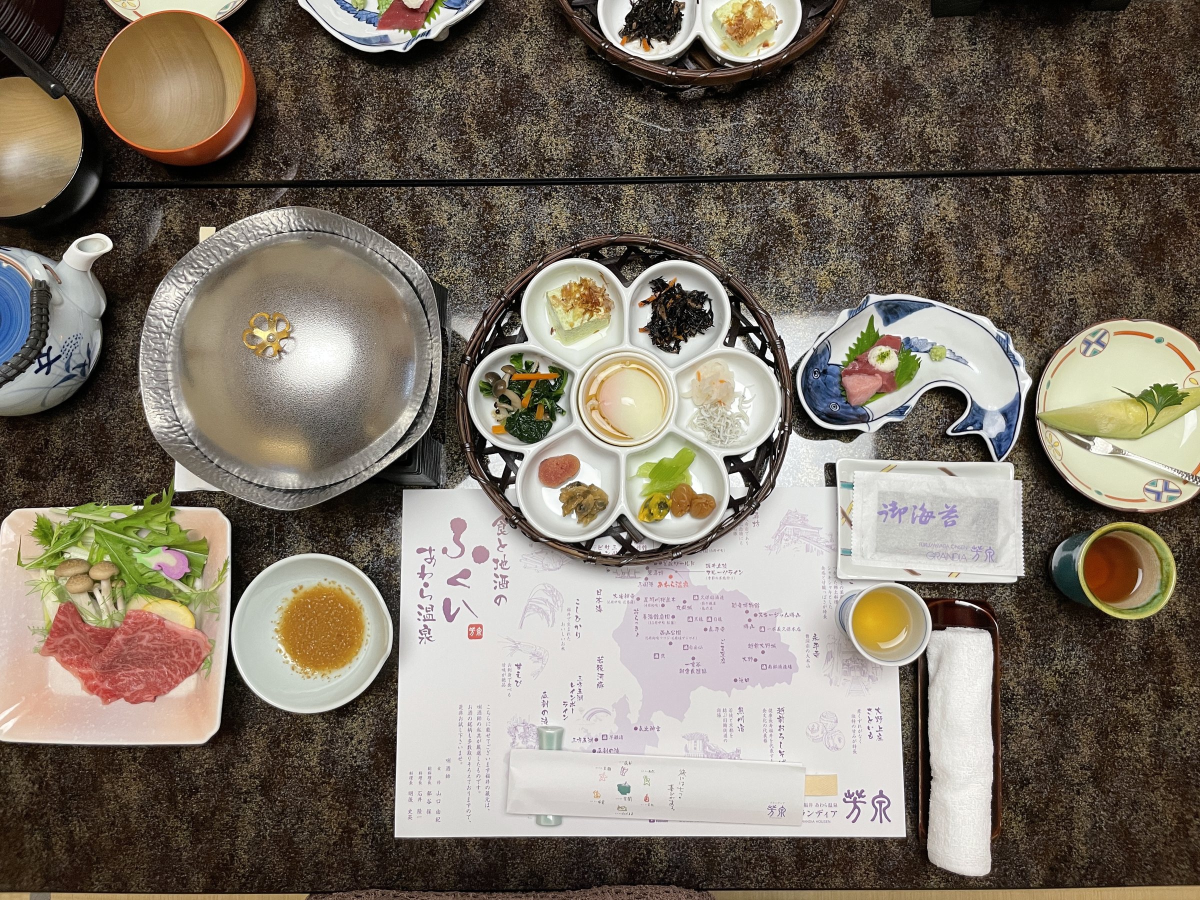 Breakfast laid out on a map of Awara Onsen, with a shabu-shabu pot.