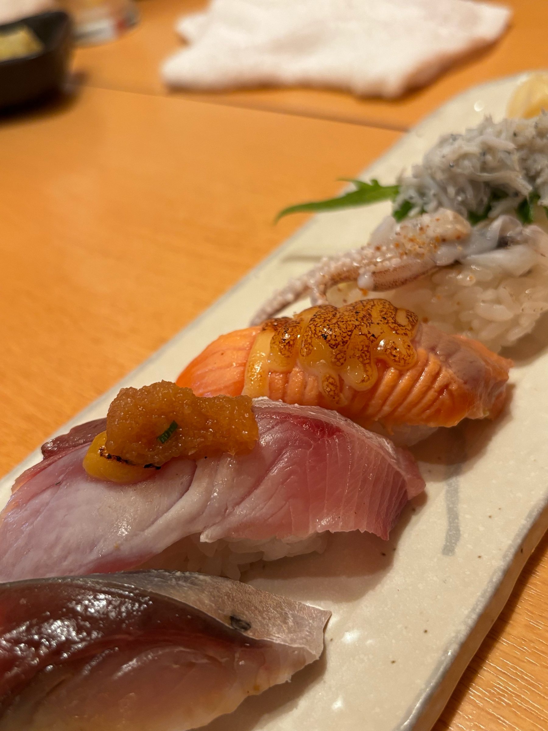 A plate of nigiri, including seared salmon.