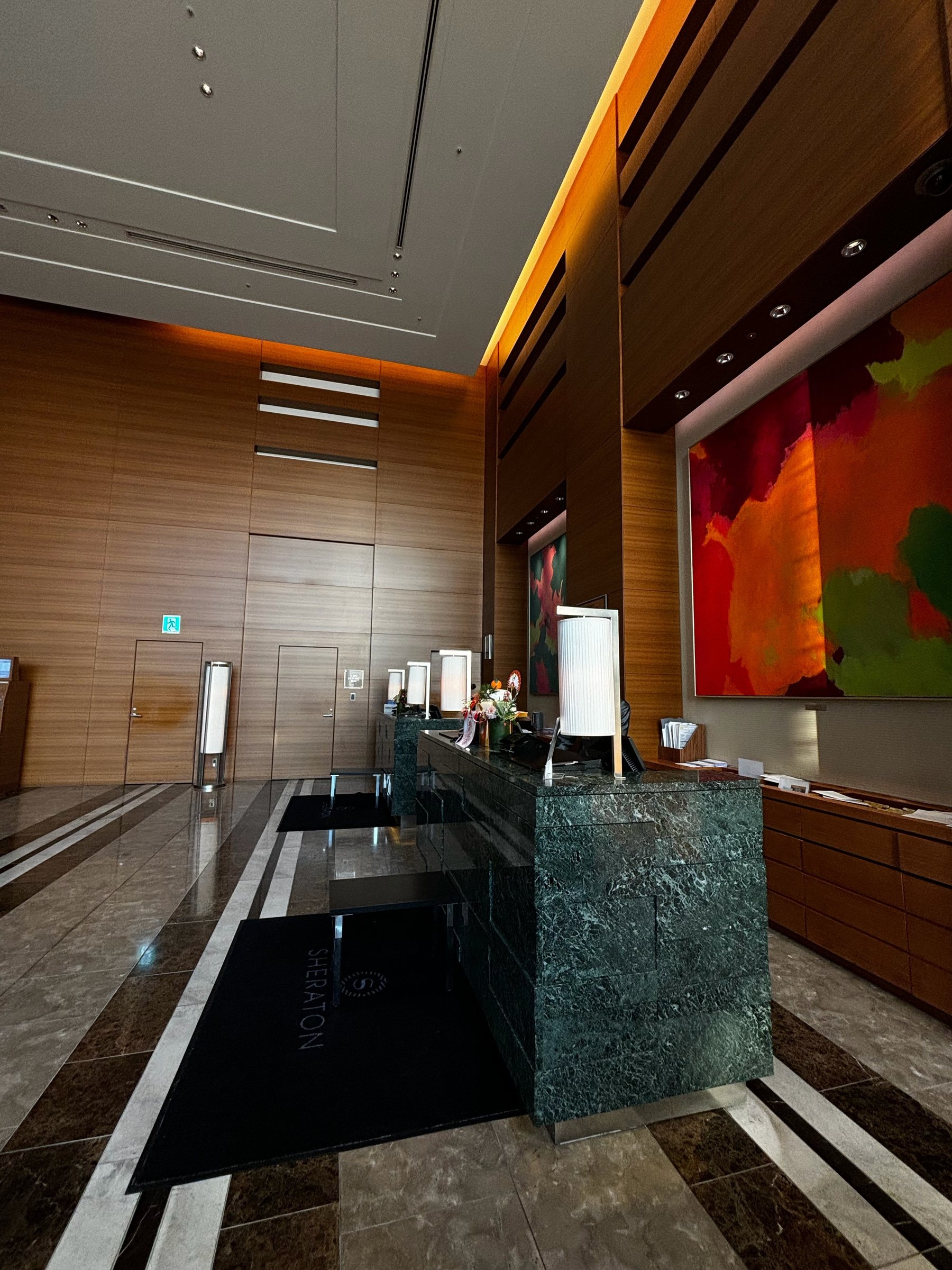 The wood-paneled front desk of the Sheraton Grand Hiroshima Hotel.