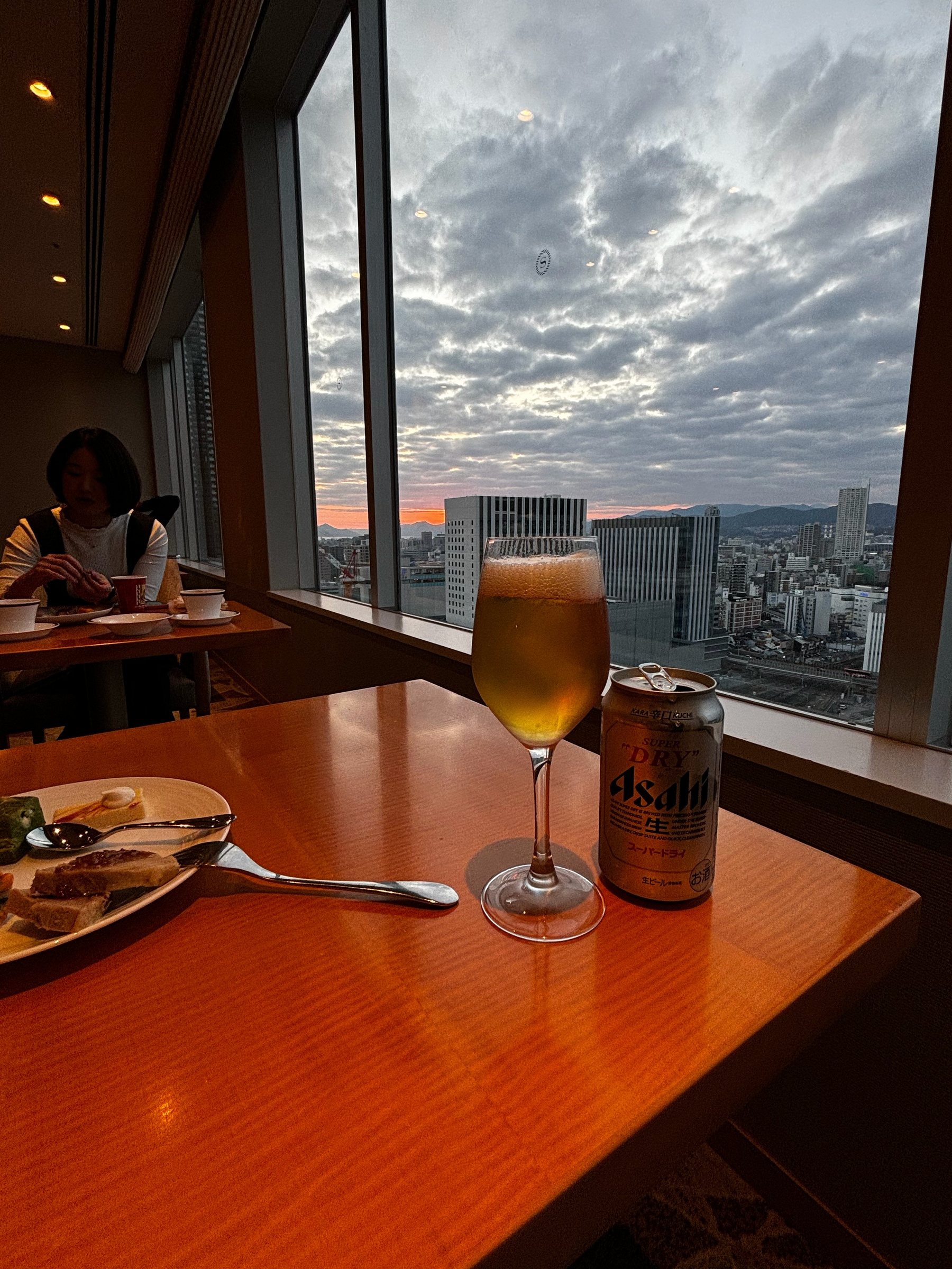 Beer in the lounge, with the evening sky over the city.