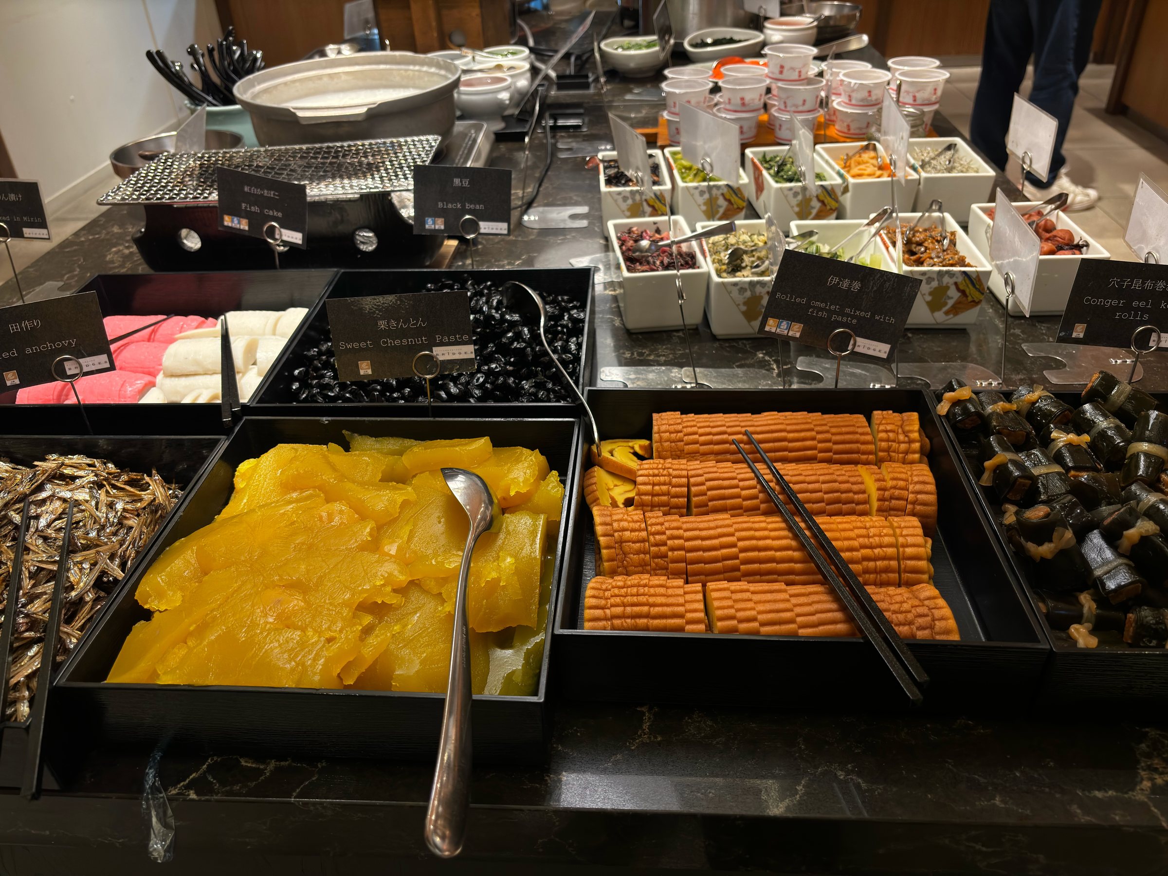 The breakfast buffet laid out with osechi: kuri kinton, kuromame and more.