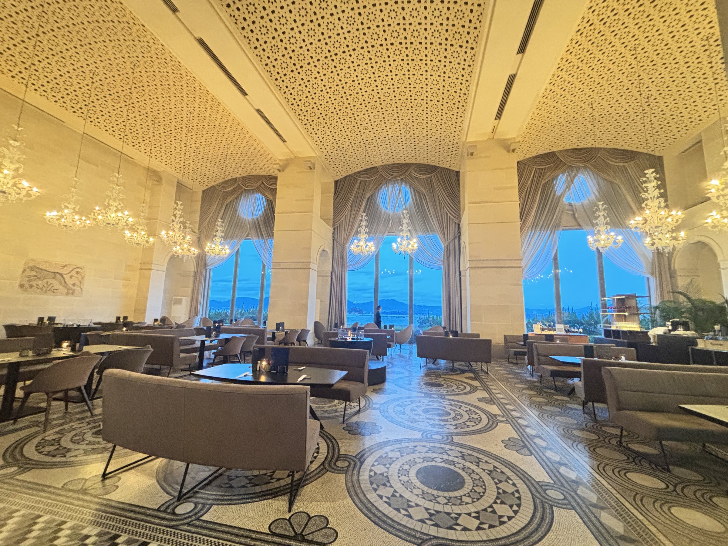 The salon, with tall arched windows onto the sea and mosaic floors.