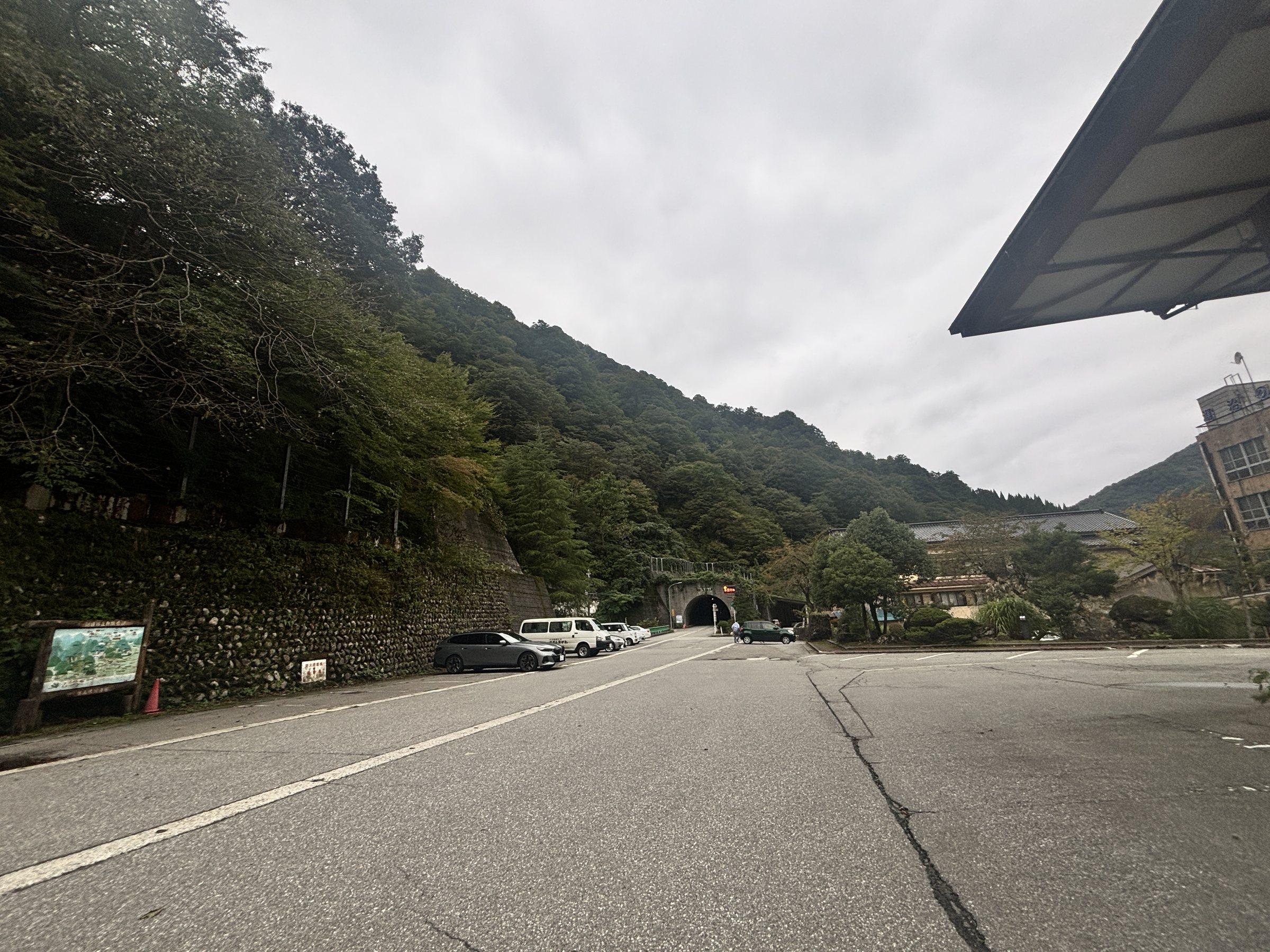 The broad parking lot, with a tunnel at the foot of the mountain beyond.