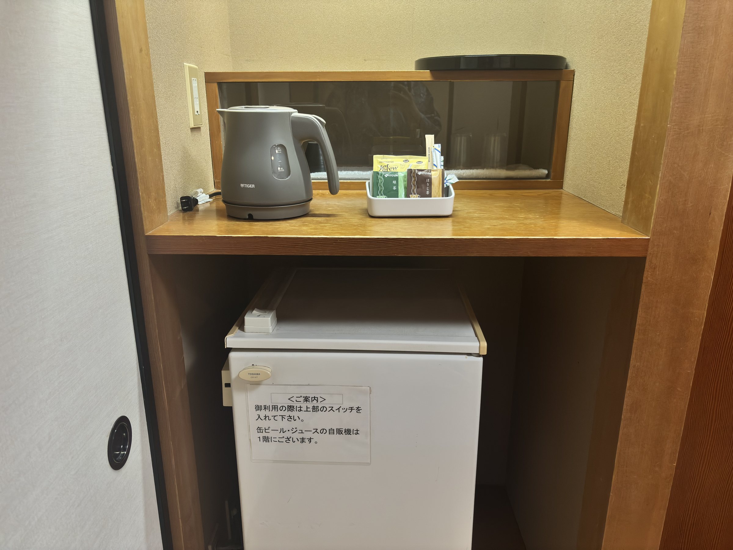 A kettle and tea set above the fridge.