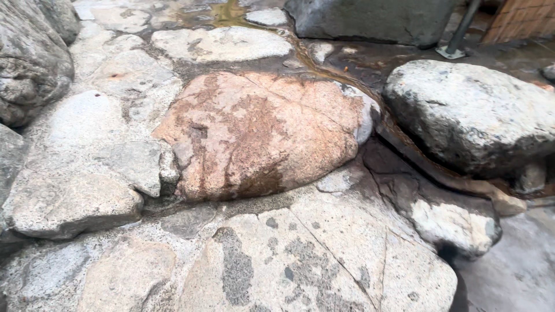 Rocks streaked with mineral deposits beside the water.