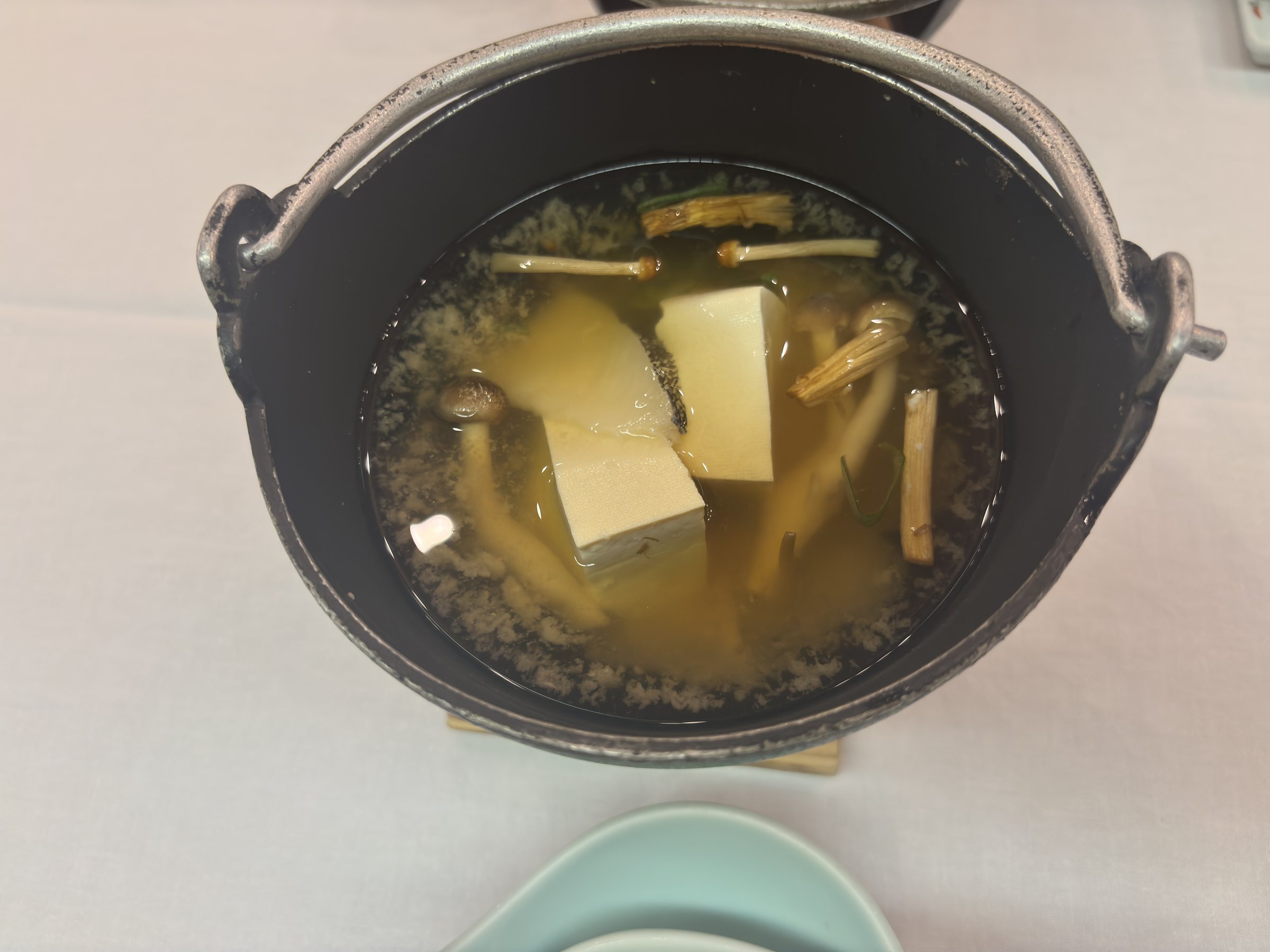 A small hot pot of tofu and vegetables.