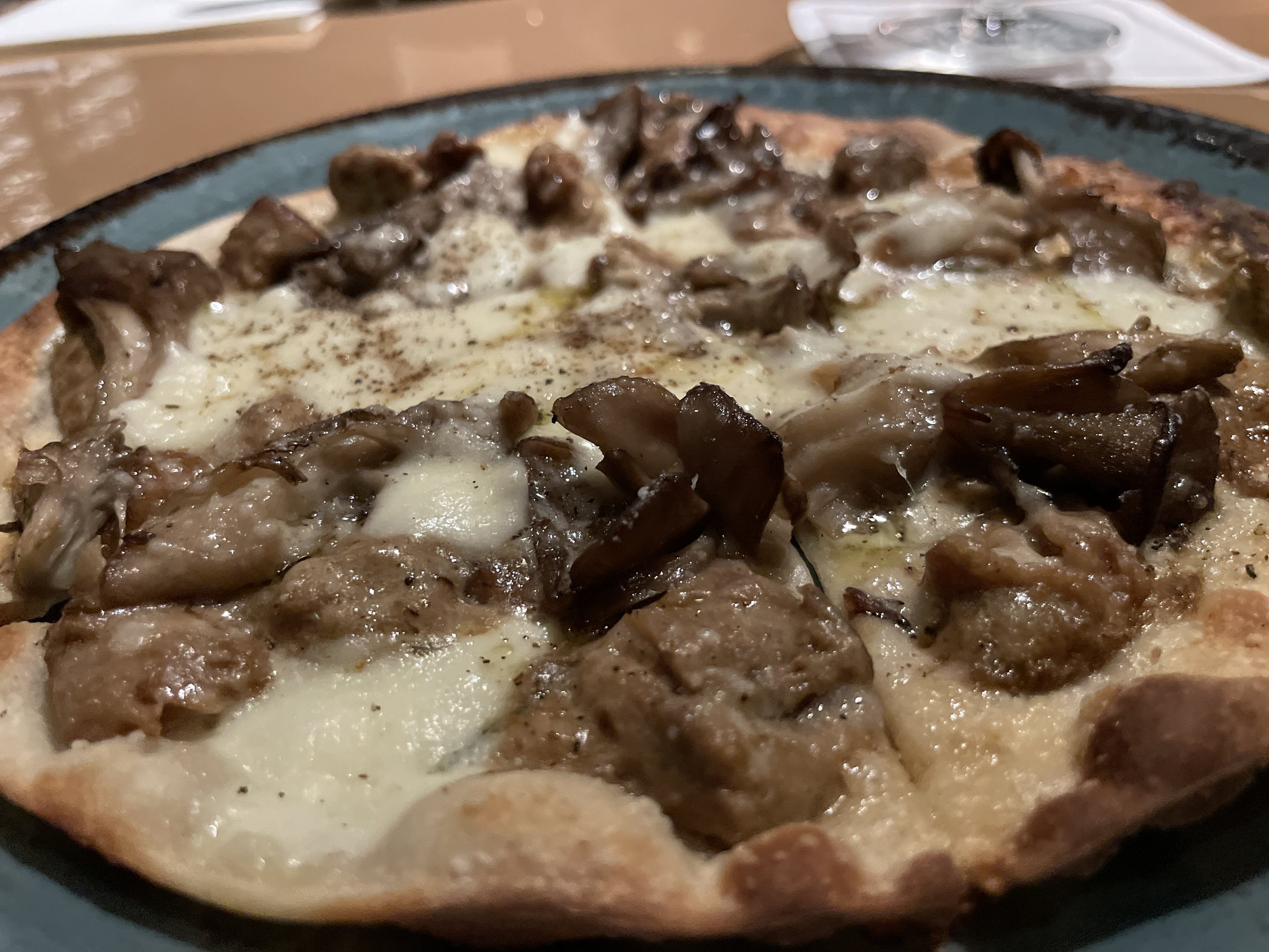 Pizza covered in mushrooms over melted cheese.