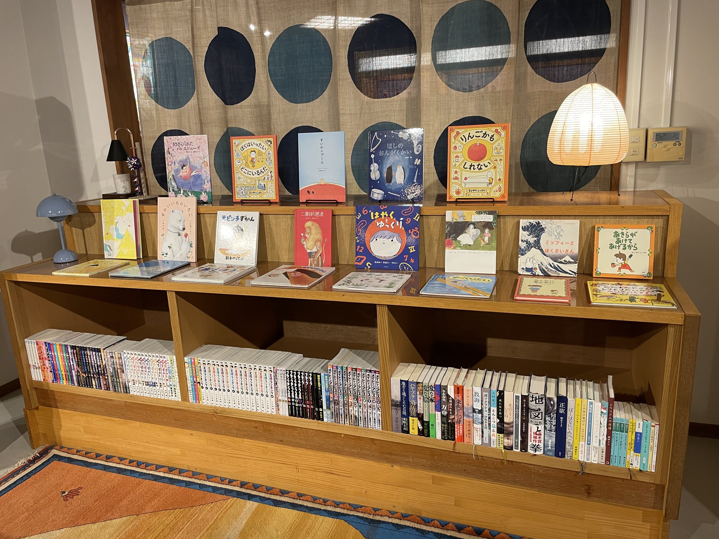 Picture books displayed face-out above shelves of manga and paperbacks.