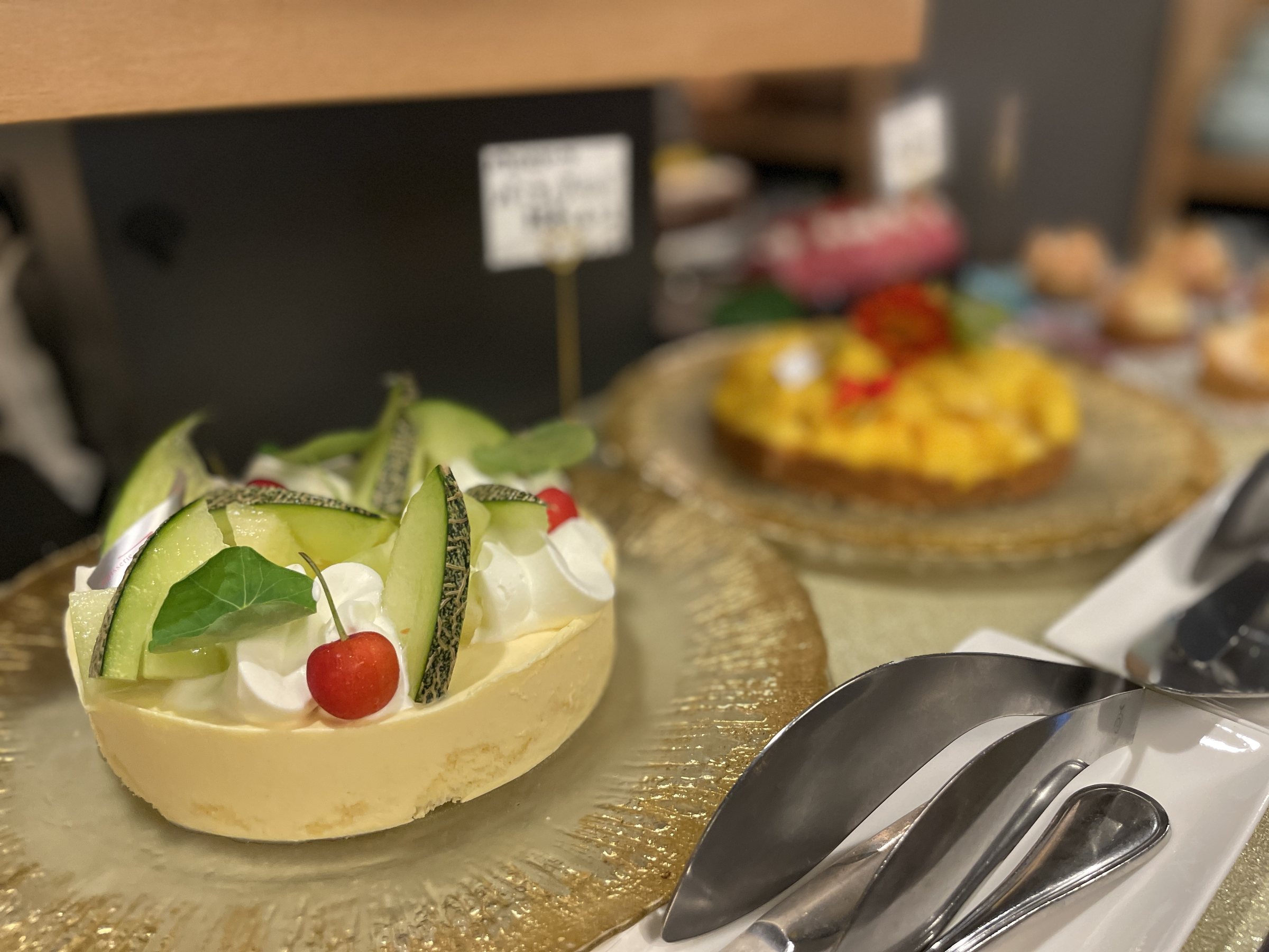 A melon cake topped with cream and a cherry.