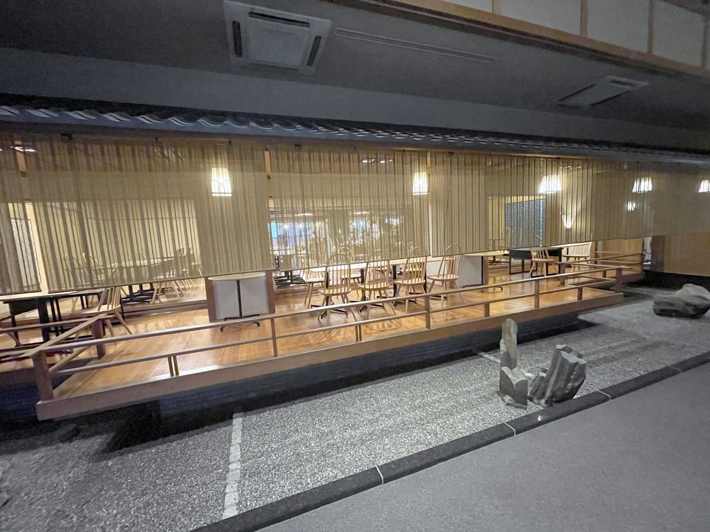 The dining hall, designed like a traditional restaurant, with bamboo blinds and stone borders.