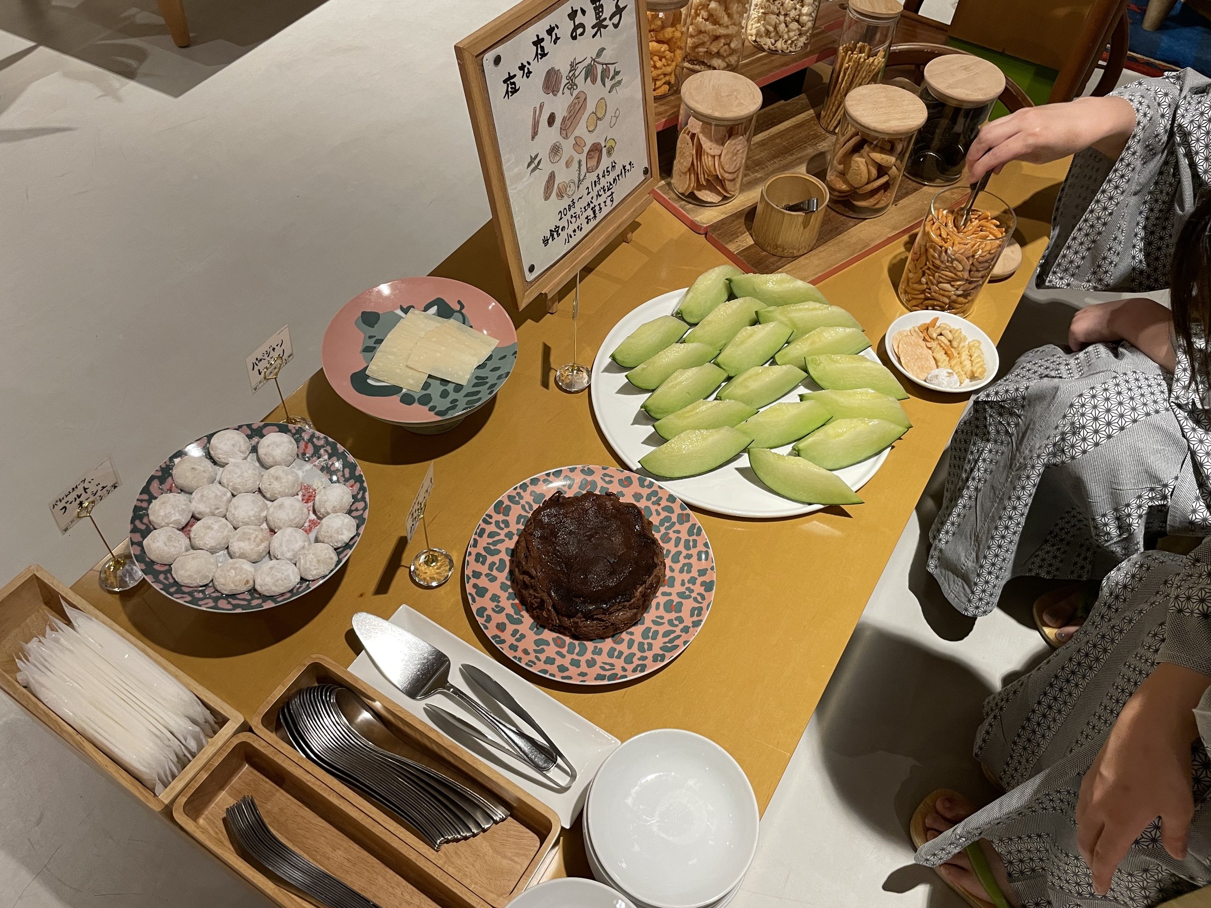 The late-night snack table: sweets, melon slices and small cakes.