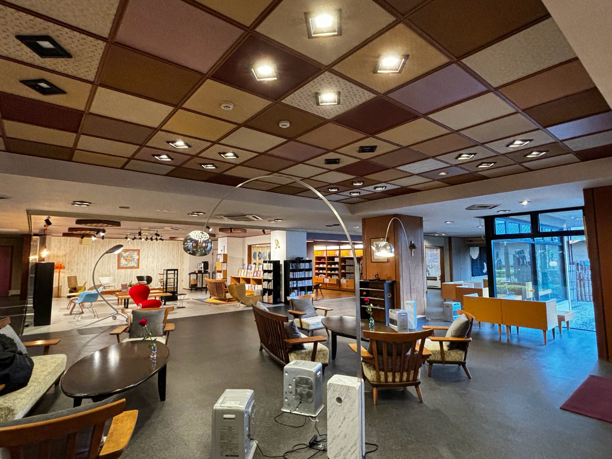 The bright lobby beneath its coffered ceiling, with armchairs and bookshelves beyond.