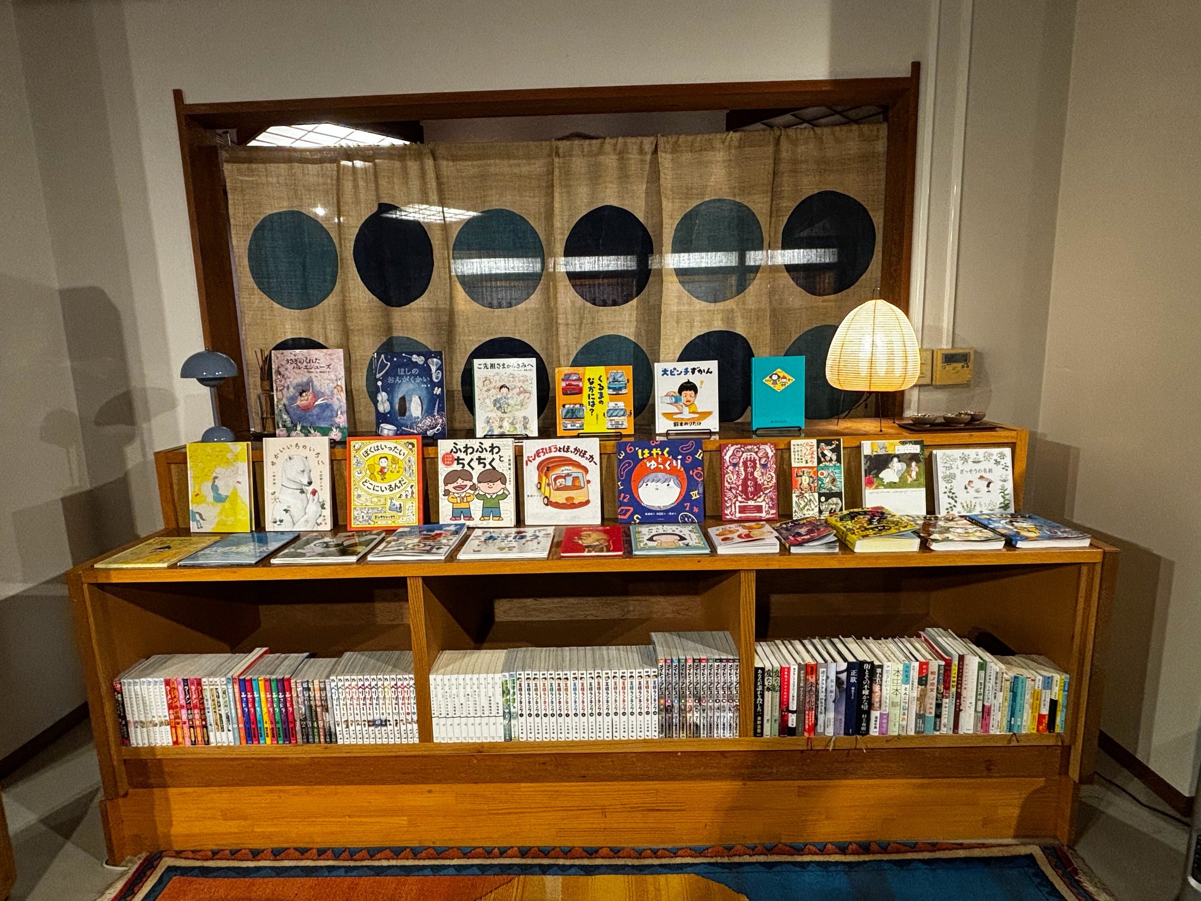 Picture books displayed face-out above shelves of manga and paperbacks.