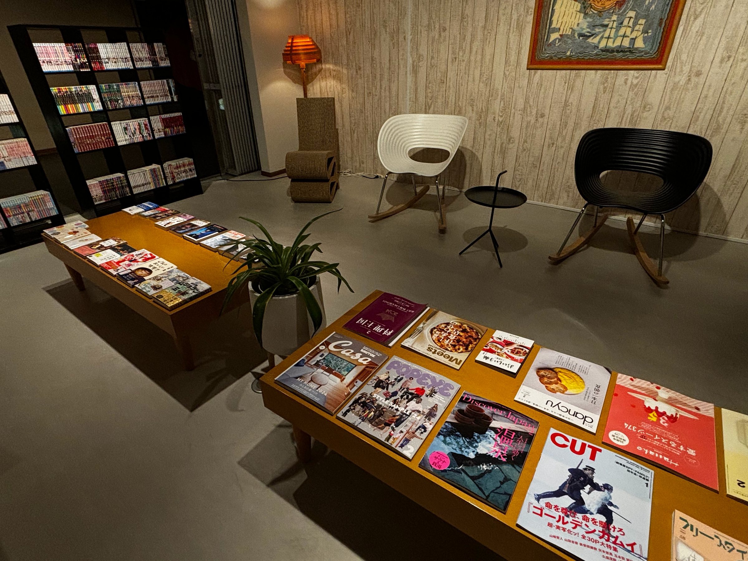 A reading corner with designer chairs, a rocking chair and a low table of magazines.
