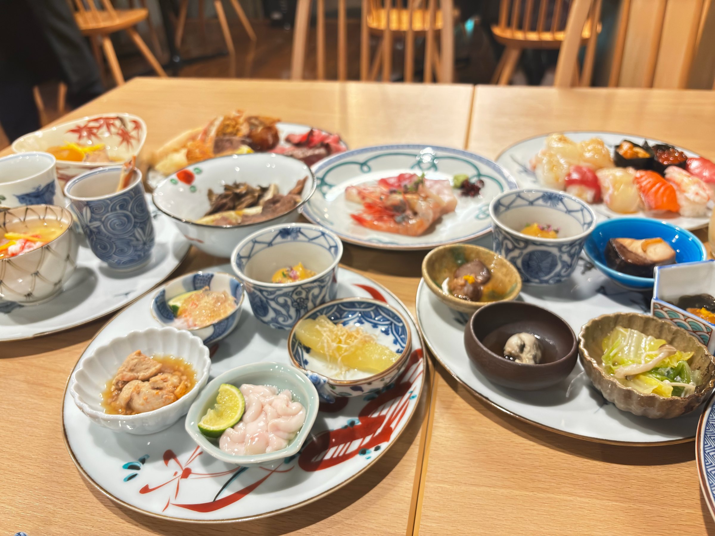 Another plate of small dishes, with sushi and salad.