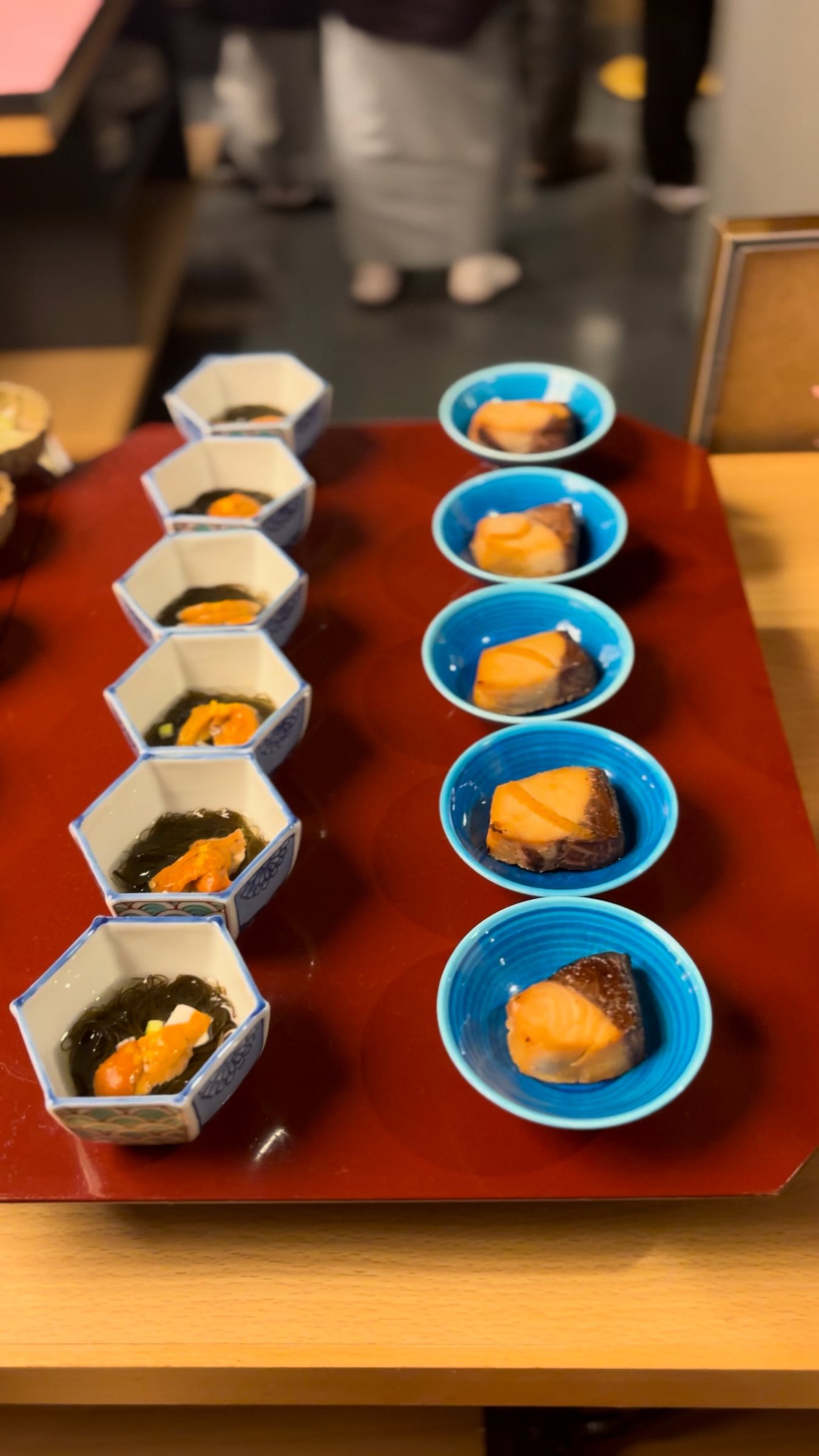 Small dishes lined up on a red lacquer tray.