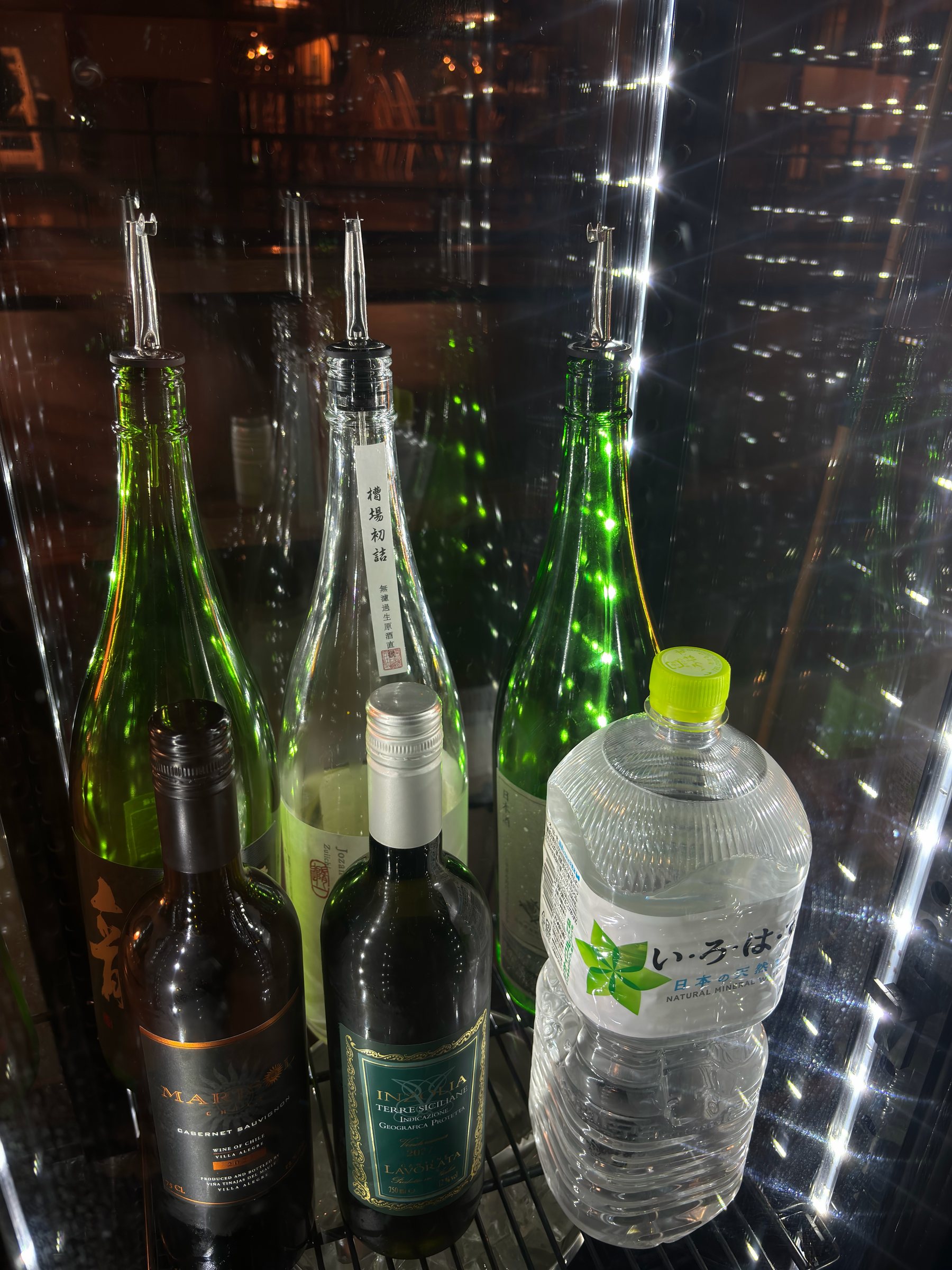 Bottles laid on their side in a chilled display cabinet.