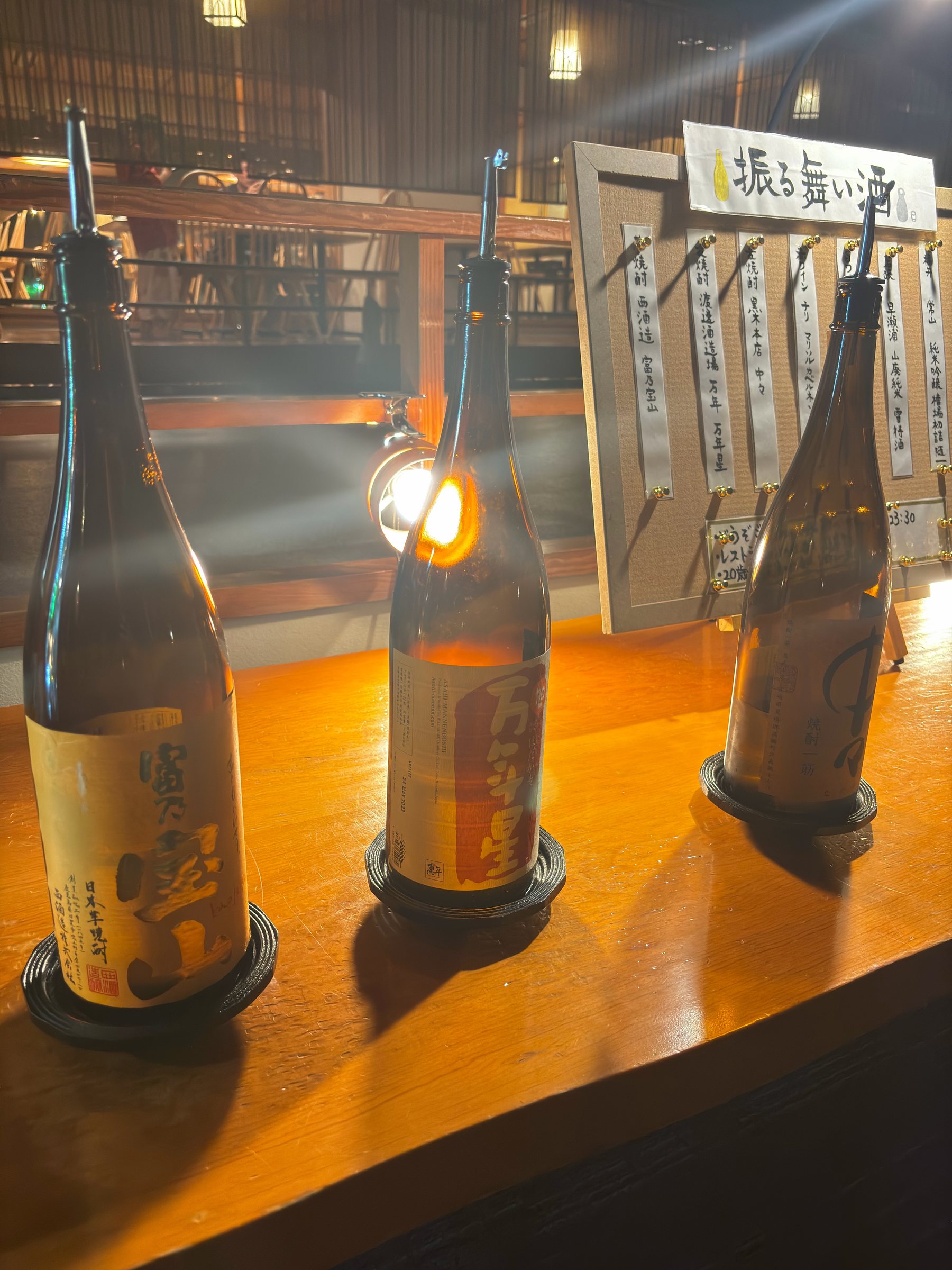 Bottles of sake on the counter, with their tasting notes.