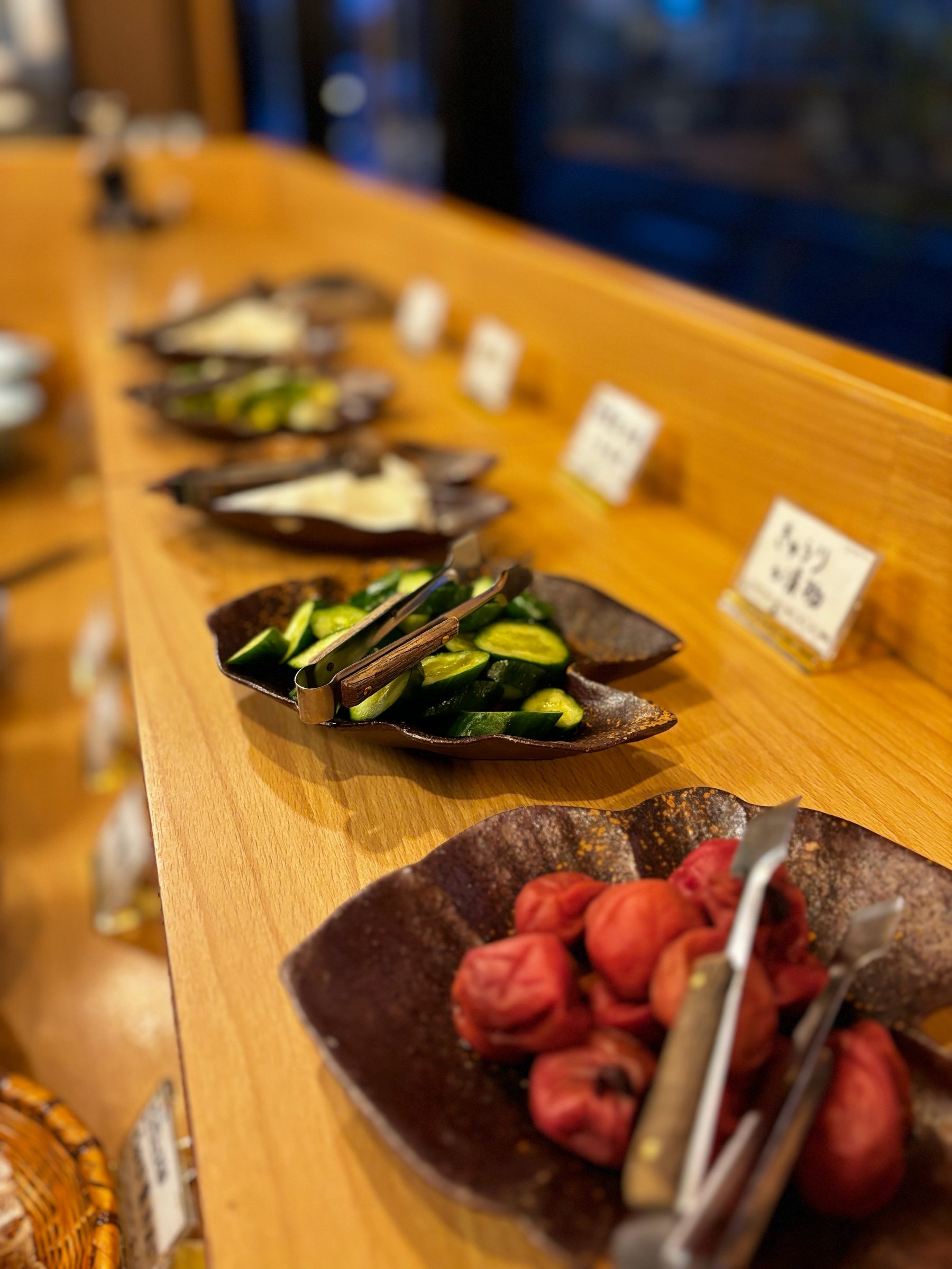 Pickles and red umeboshi plums laid out along the breakfast counter.