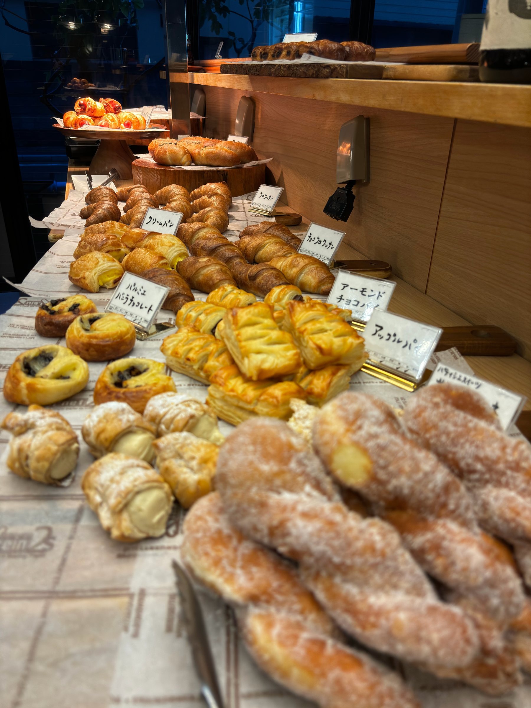 Sugared twists, Danish pastries and other breads, each with a name card.
