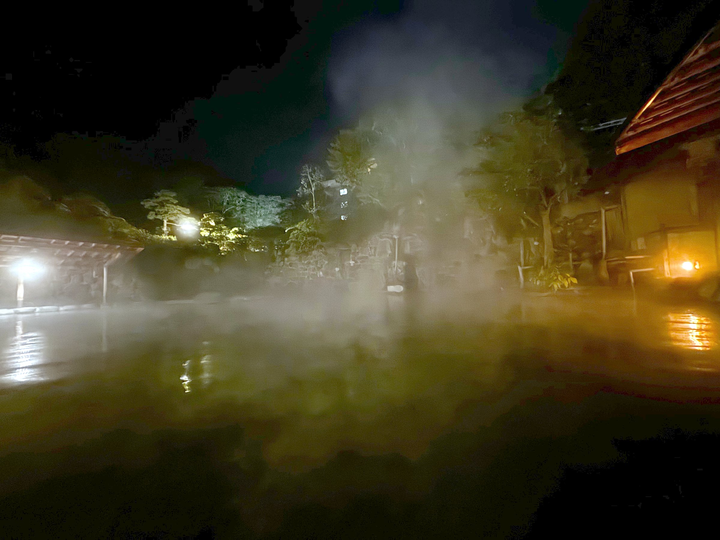 The great open-air bath at night, wrapped in steam.