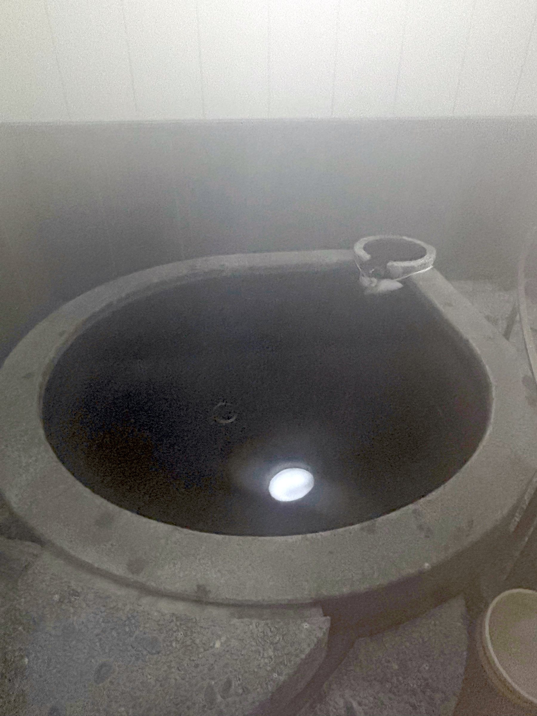 The round stone bath for one, lit from below.