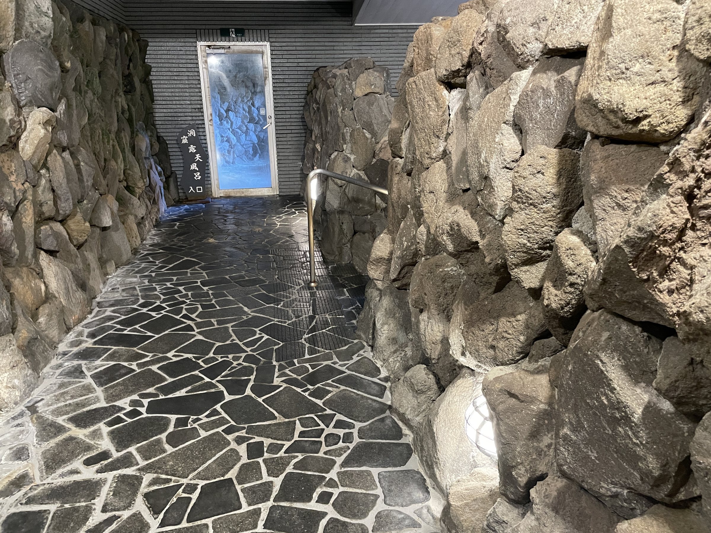 A passage between walls of rough volcanic stone.