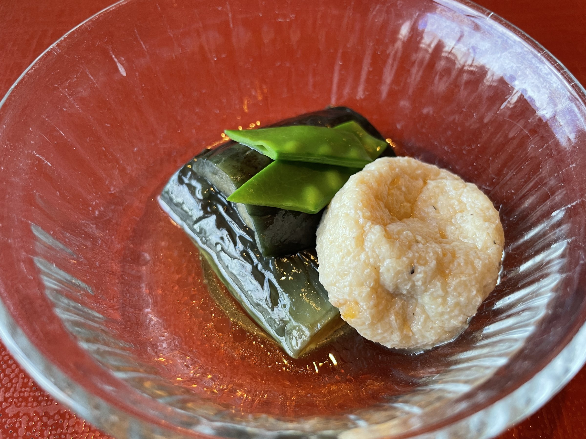 Fried eggplant and a ganmodoki tofu fritter, served chilled in broth with snow peas.