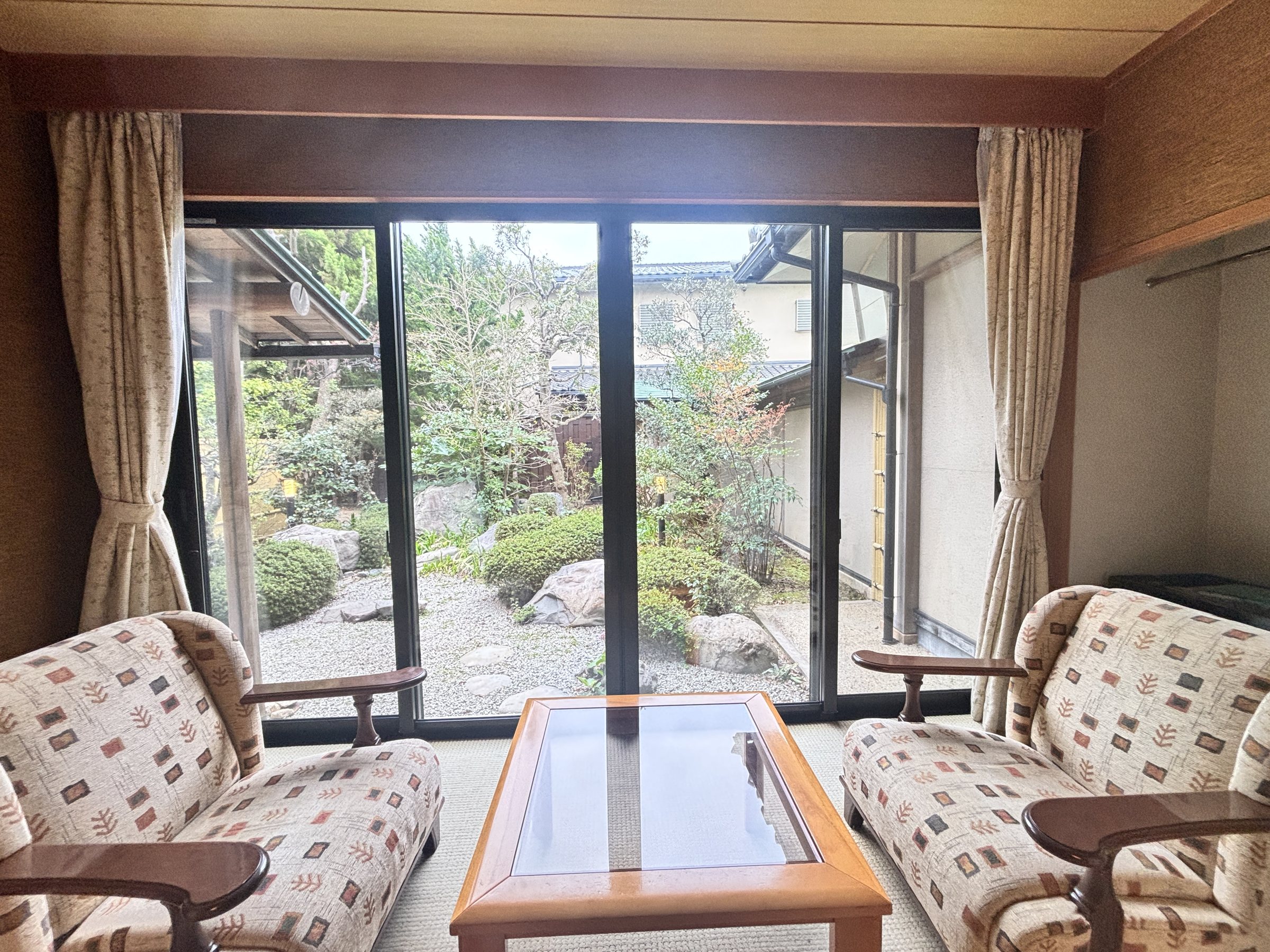 Armchairs by the window, looking onto the garden.