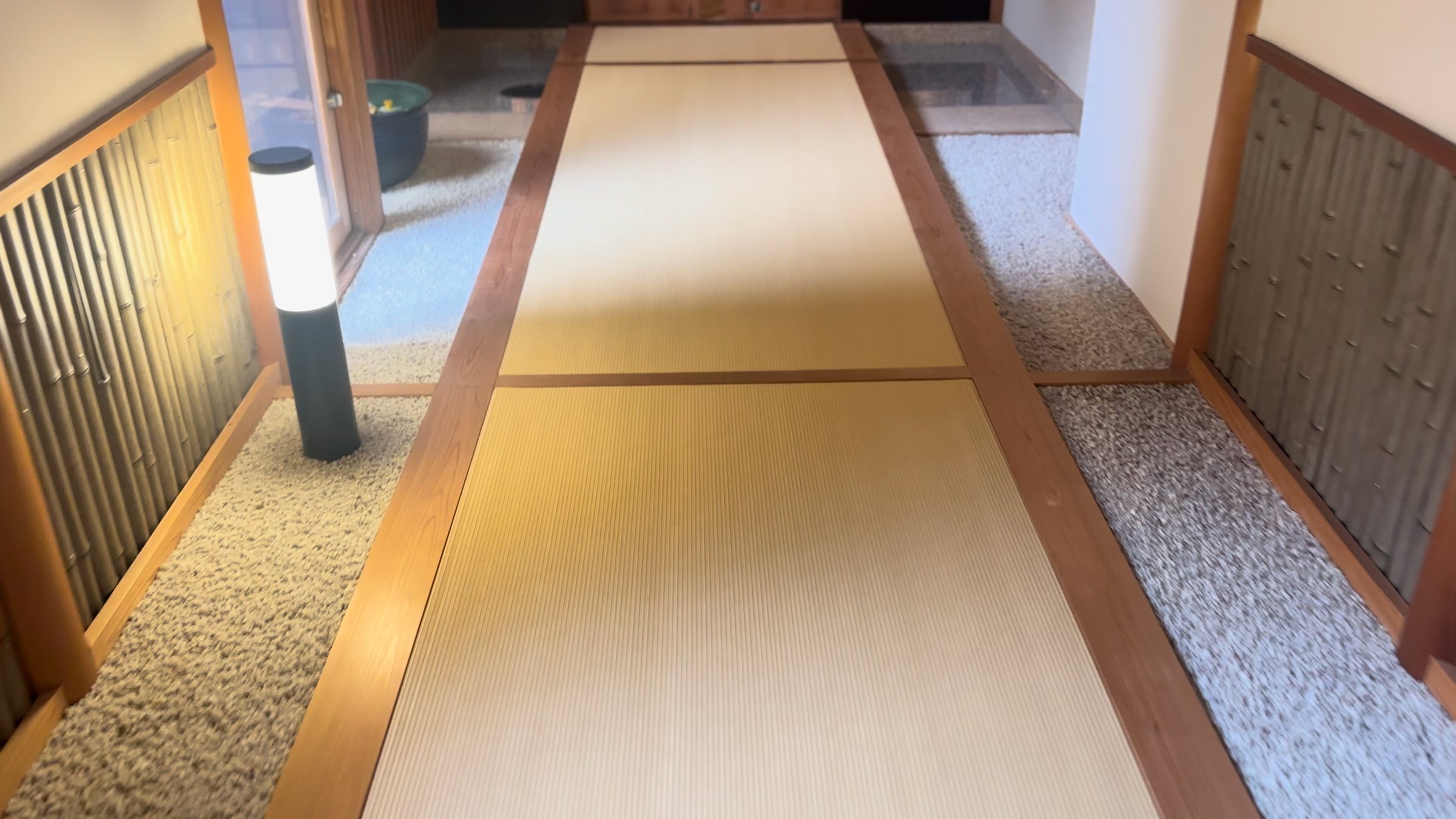 A tatami walkway bordered by white gravel.