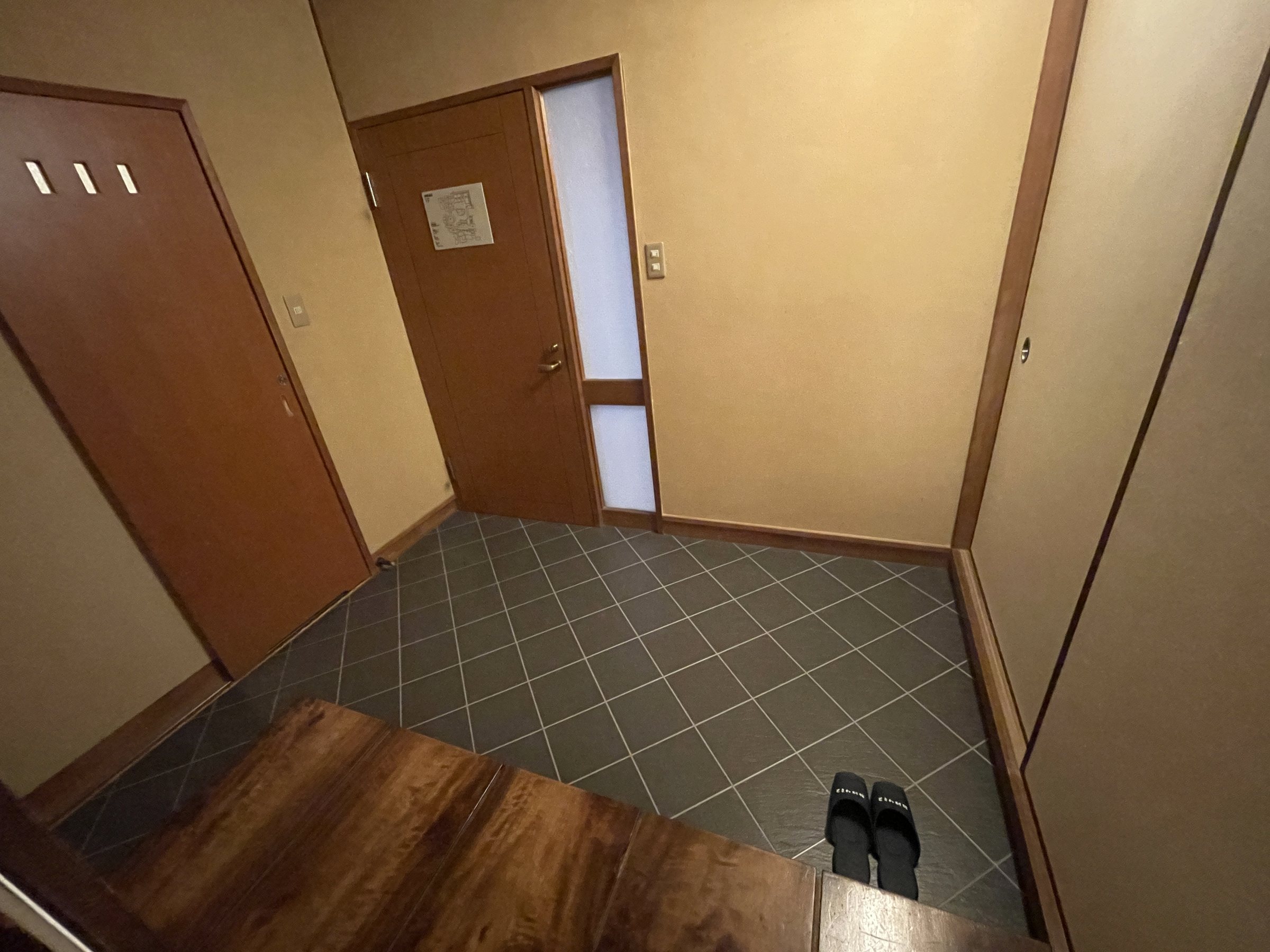 The room’s entrance hall, with slippers set out on the tiled floor.