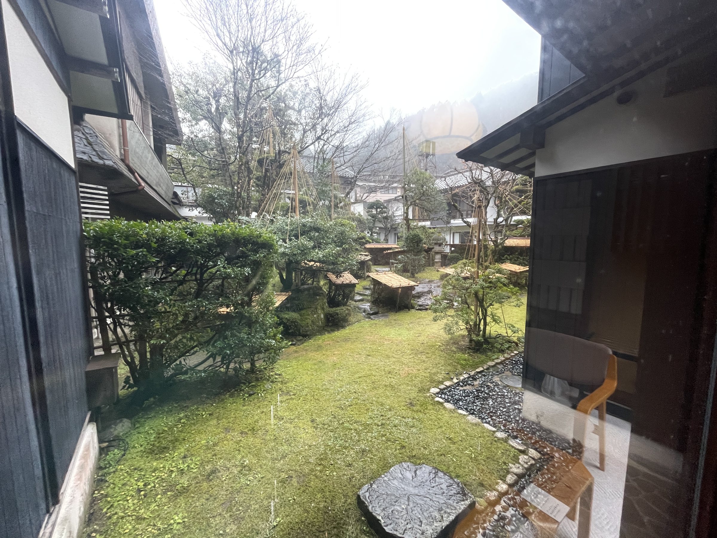 The garden, with stepping stones, clipped shrubs and the hills beyond.