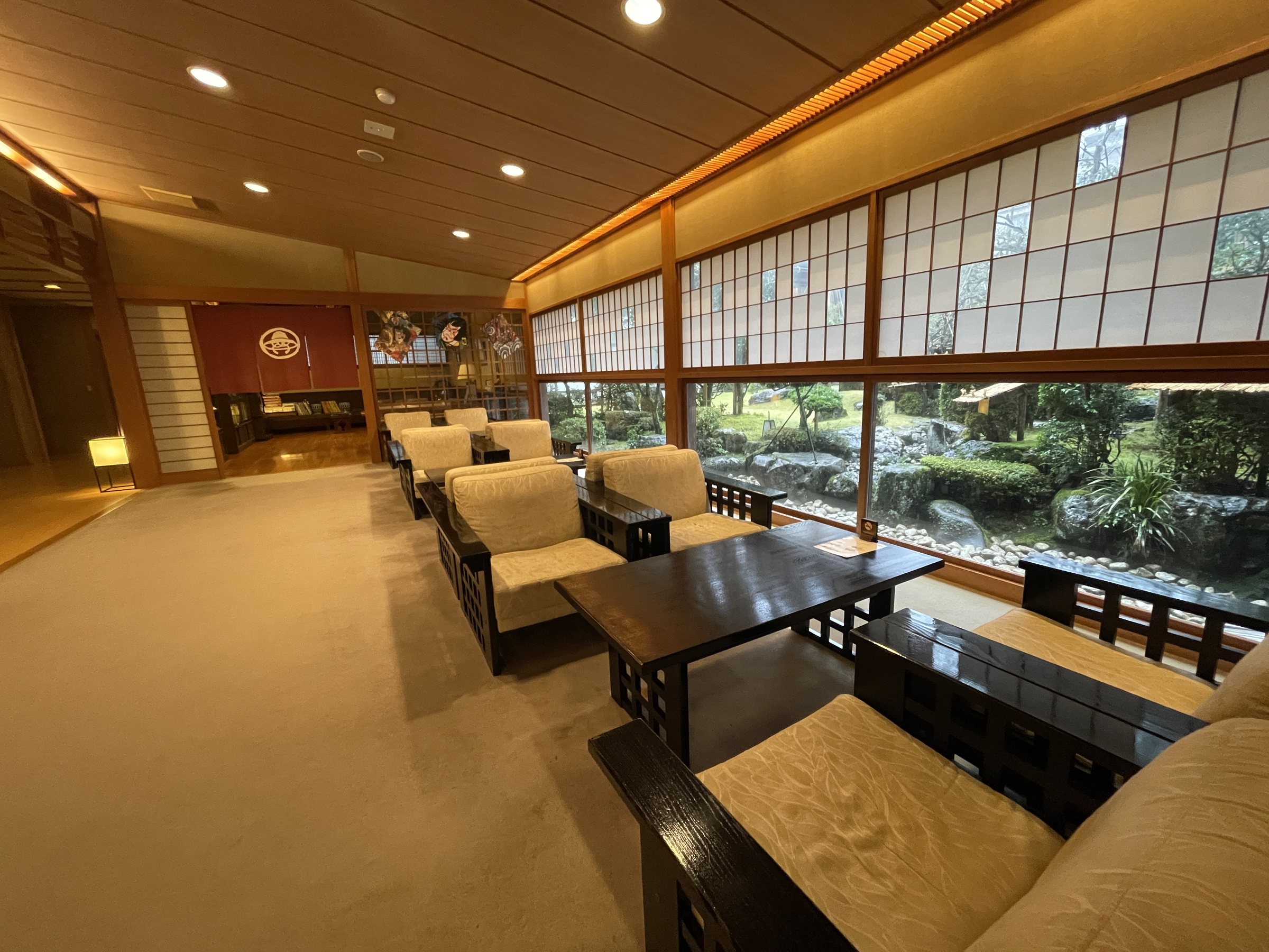 A spacious lounge with armchairs facing the garden.